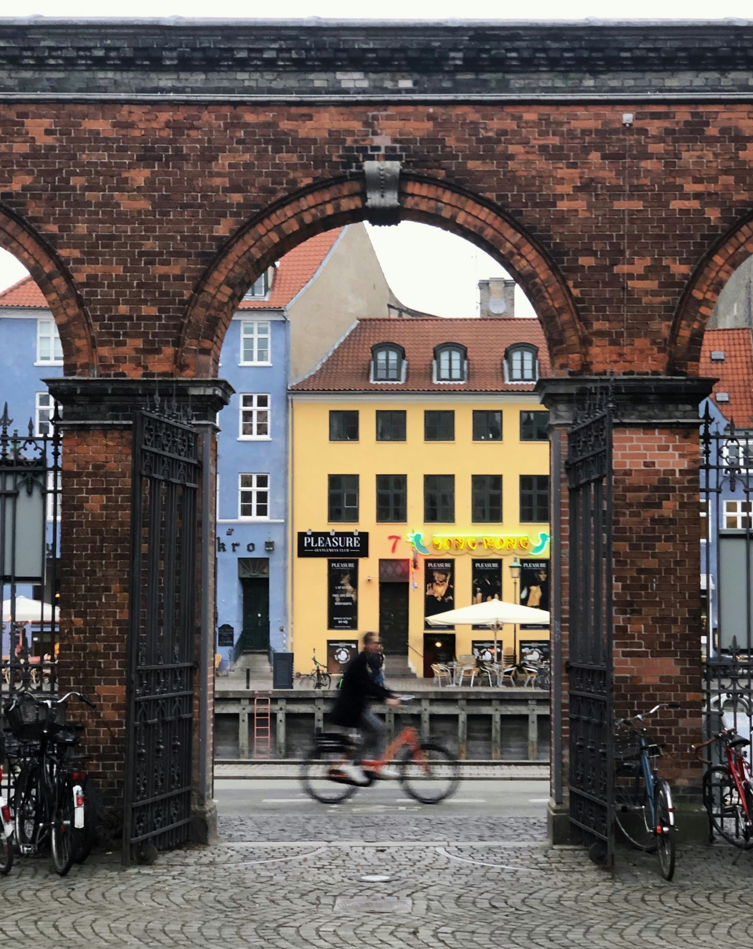 A cyclist riding through an old brick archway
