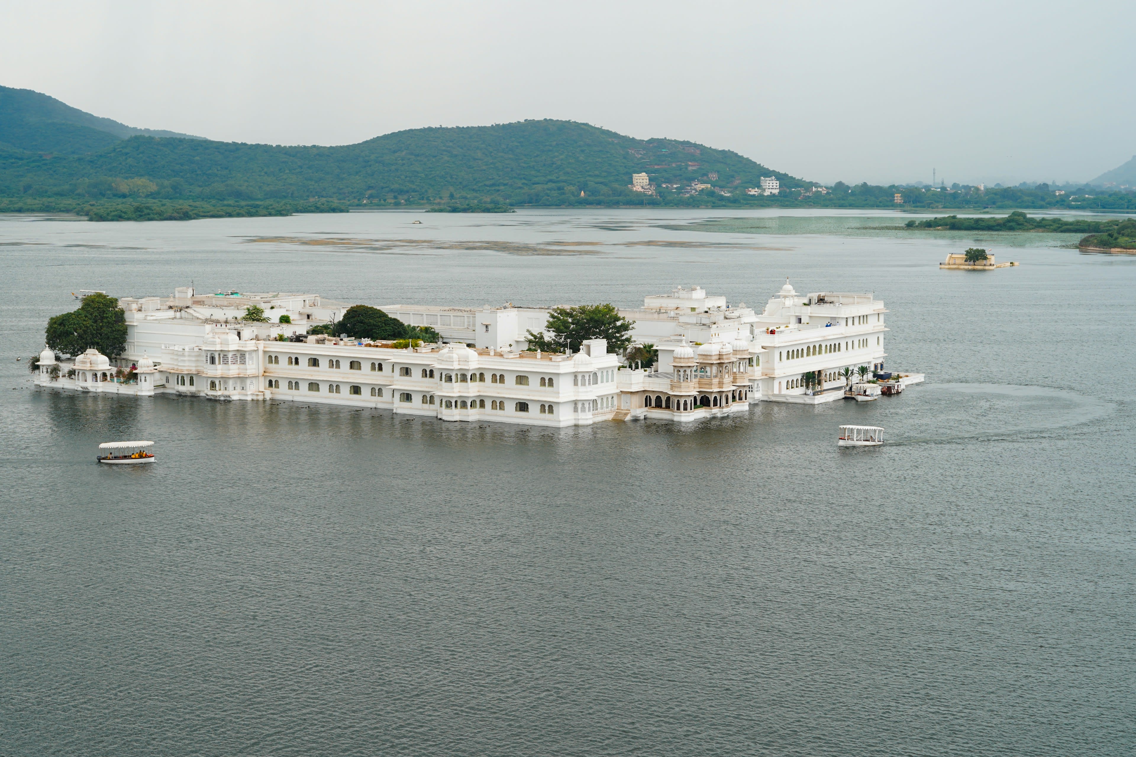 A white marble palace sitting on the waters of a lake