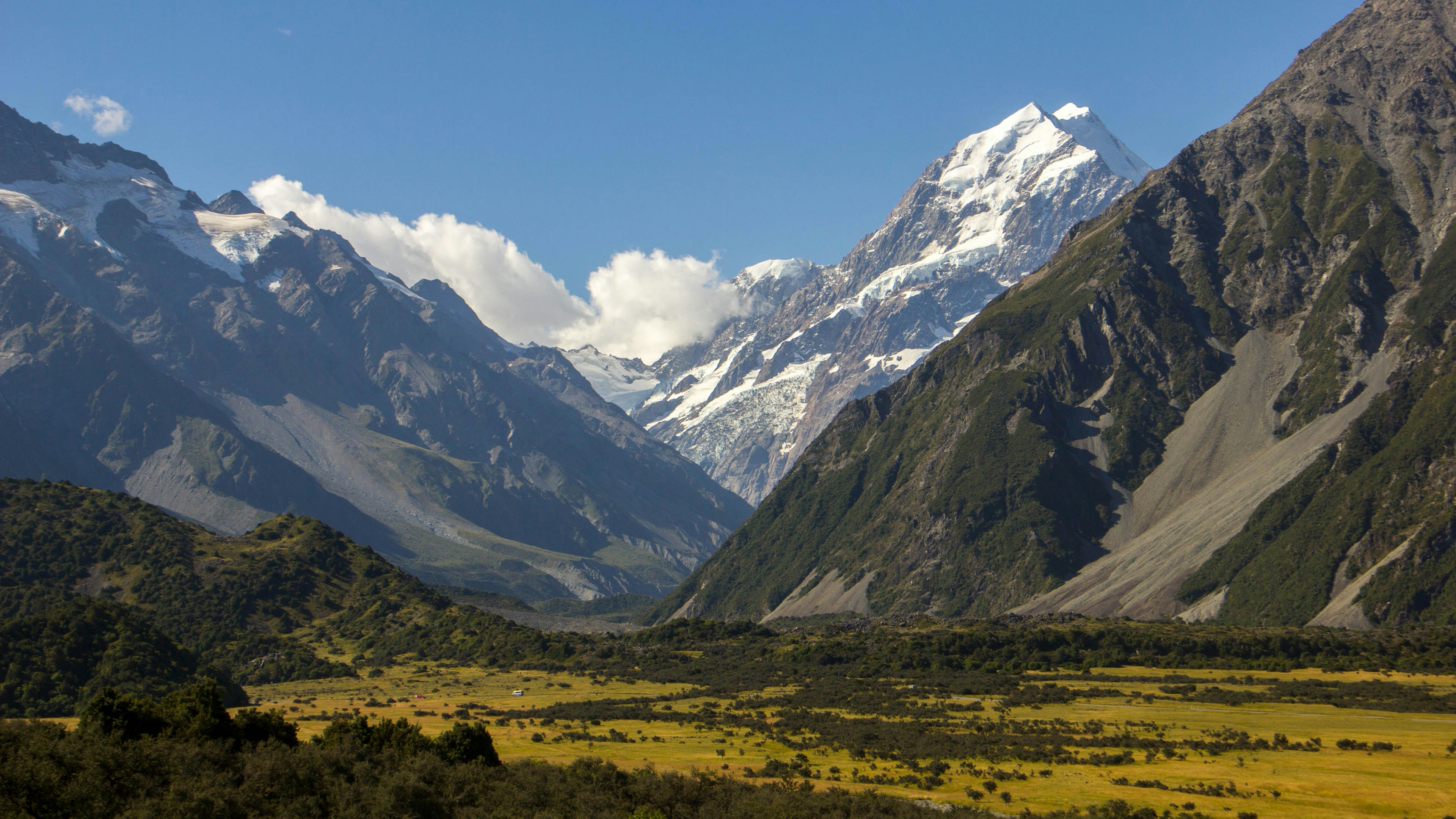 A golden valley leading to the snow-covered face of Aoraki Mount Cook