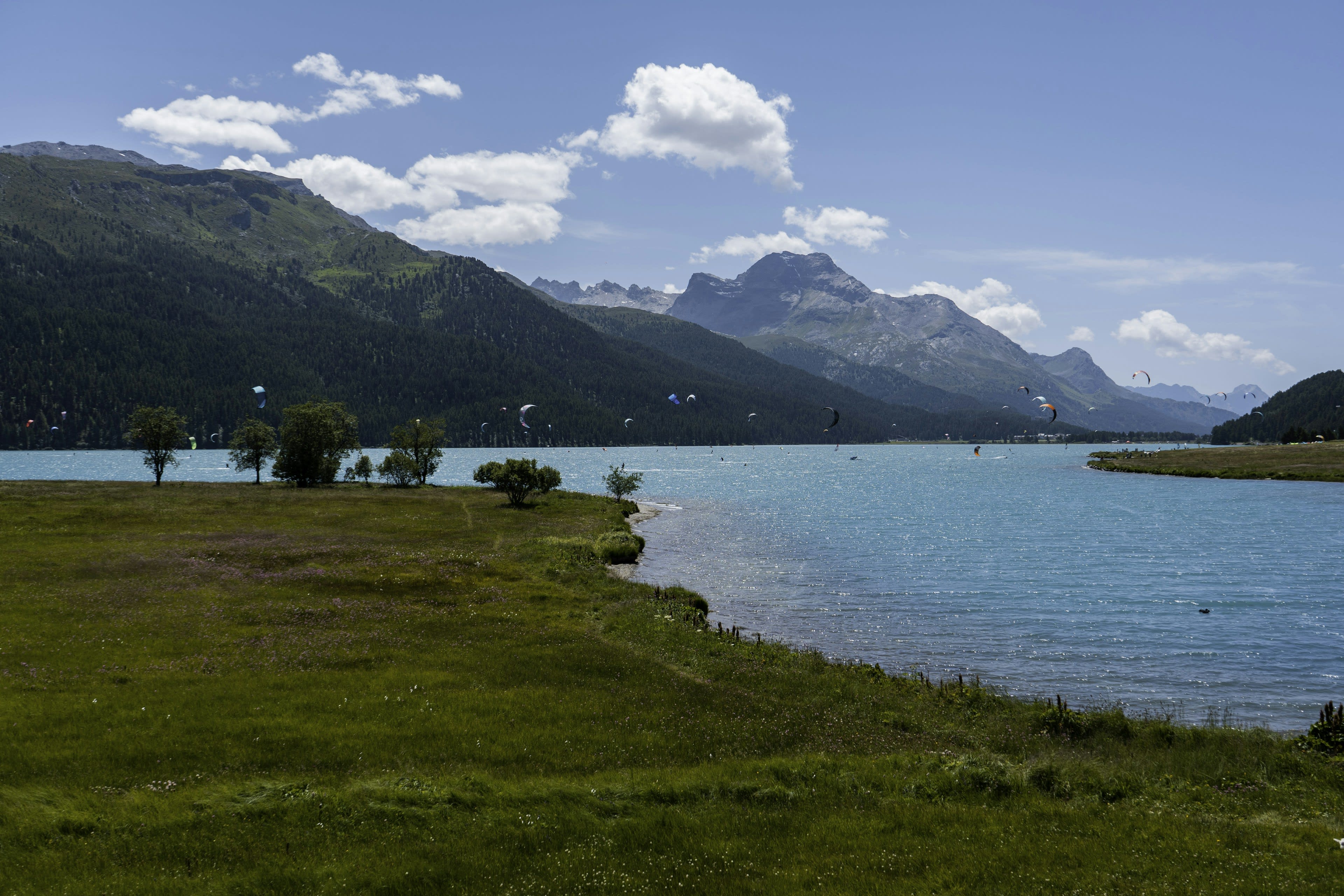 A cold alpine lake ringed by mountains under moving cloud