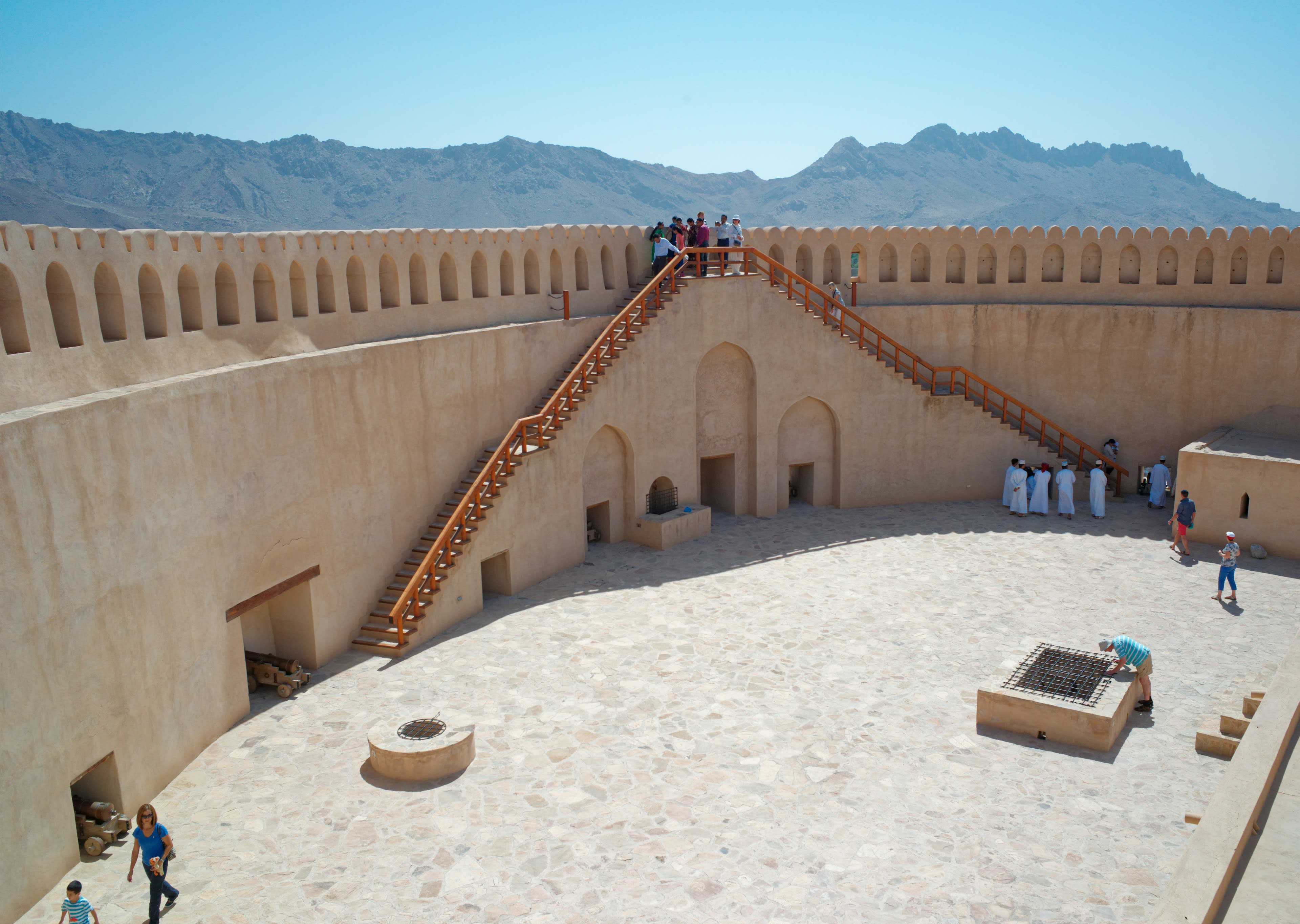 People standing atop a massive round fort tower