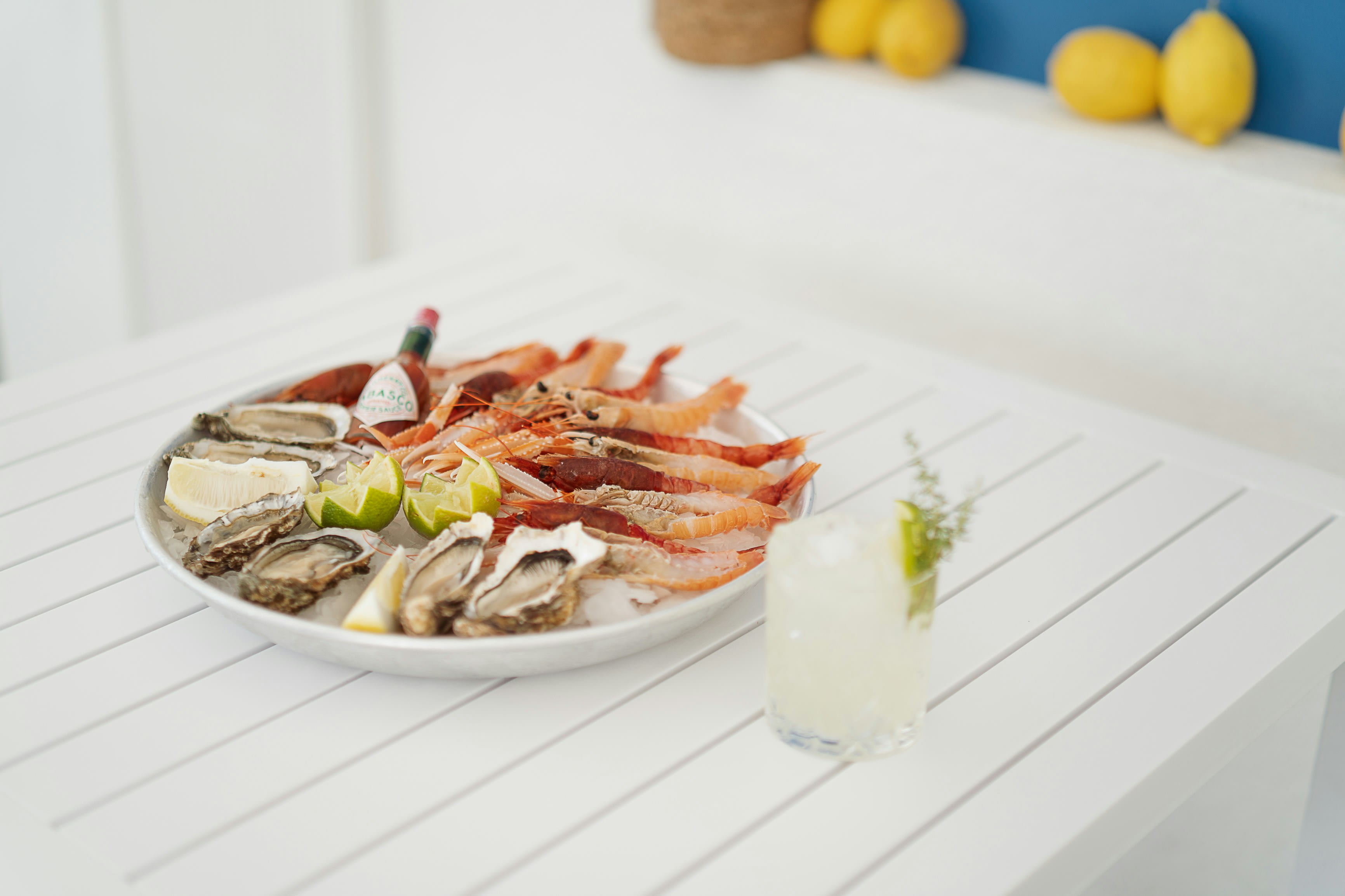 A plate of prawns on a white taverna table by the sea