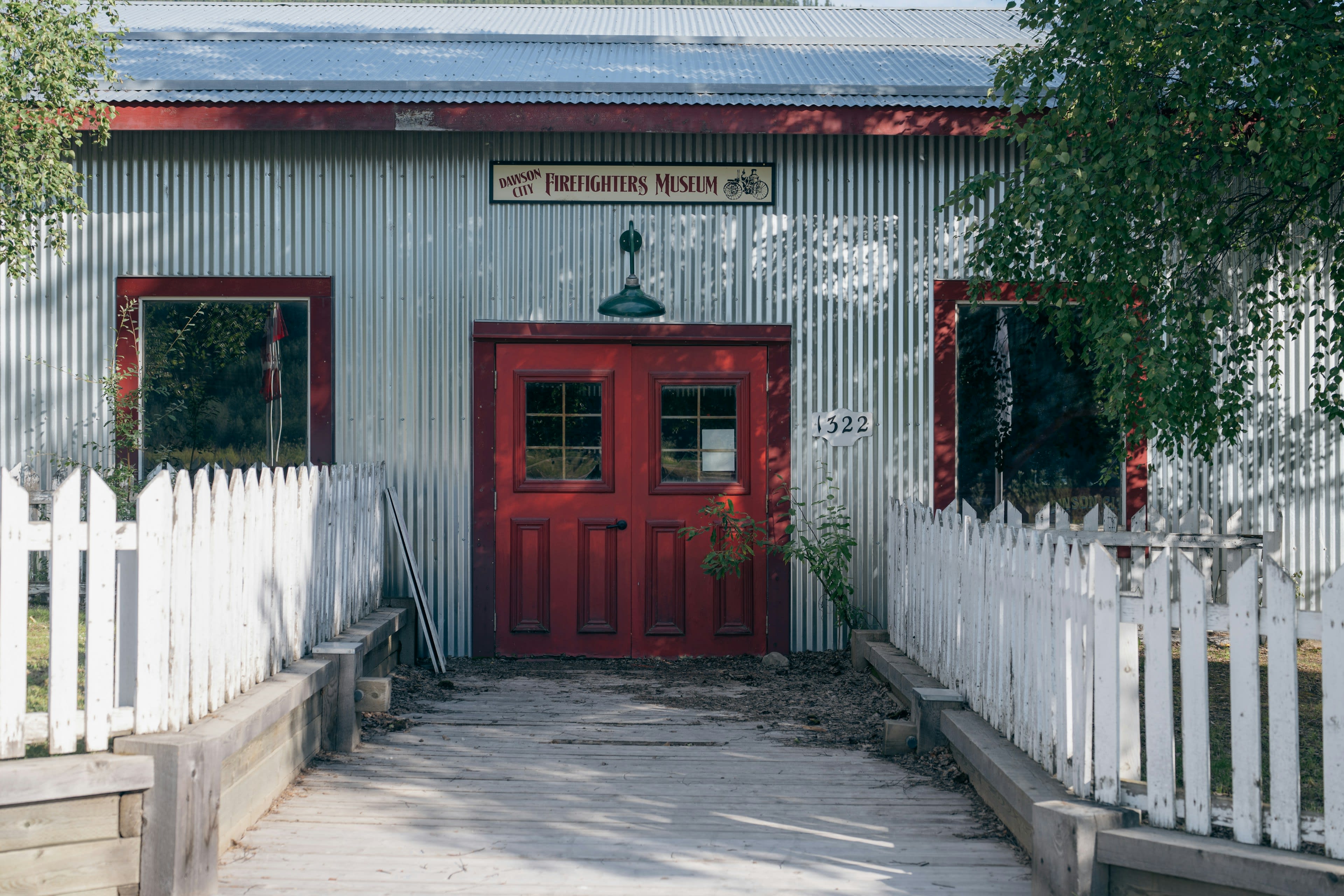 A weathered rustic building with a bright red door in Dawson City