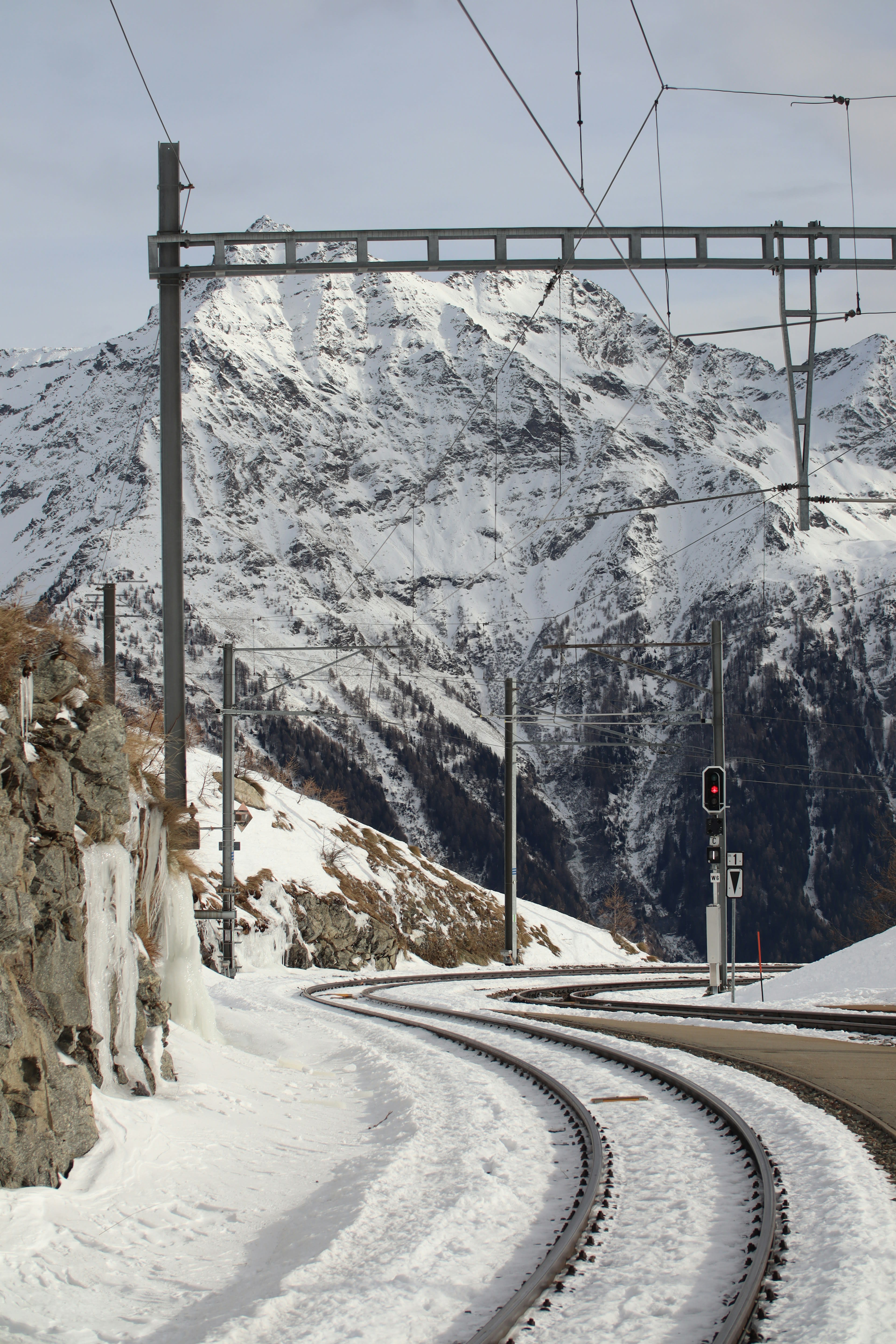 Snow-covered railway tracks curving through white mountains
