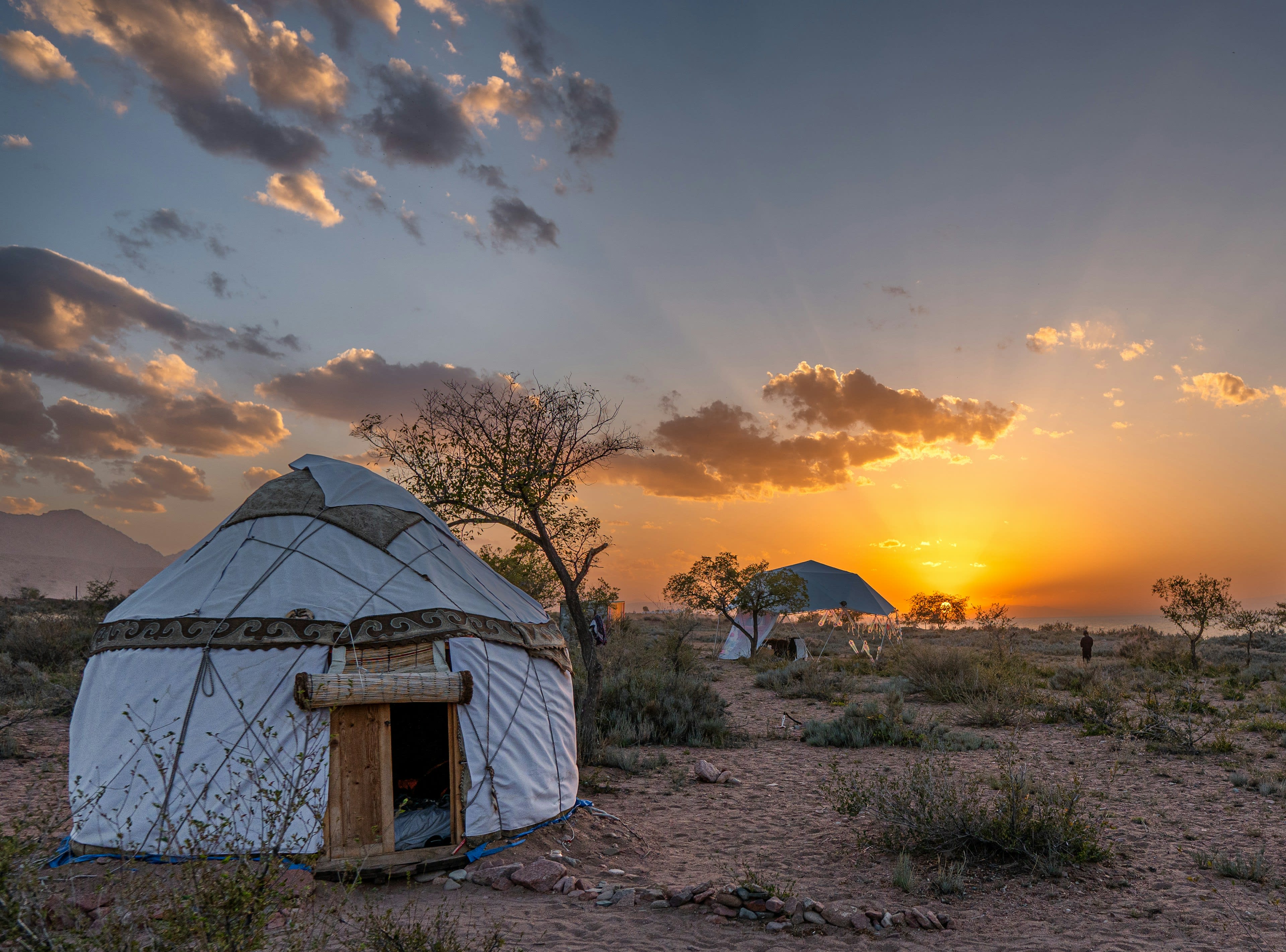 A yurt standing alone on a high desert plain at dusk