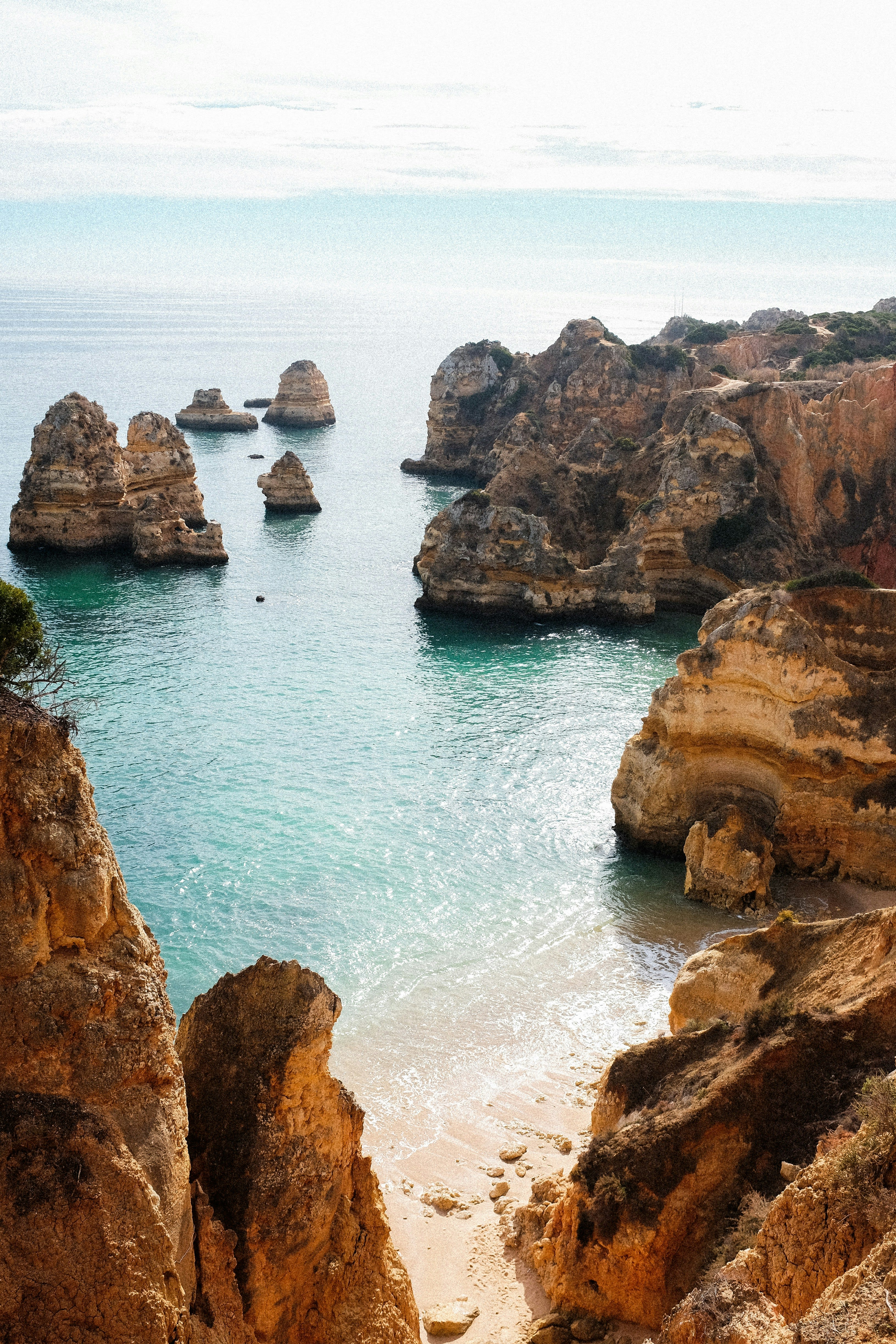A small turquoise cove enclosed by golden rock formations