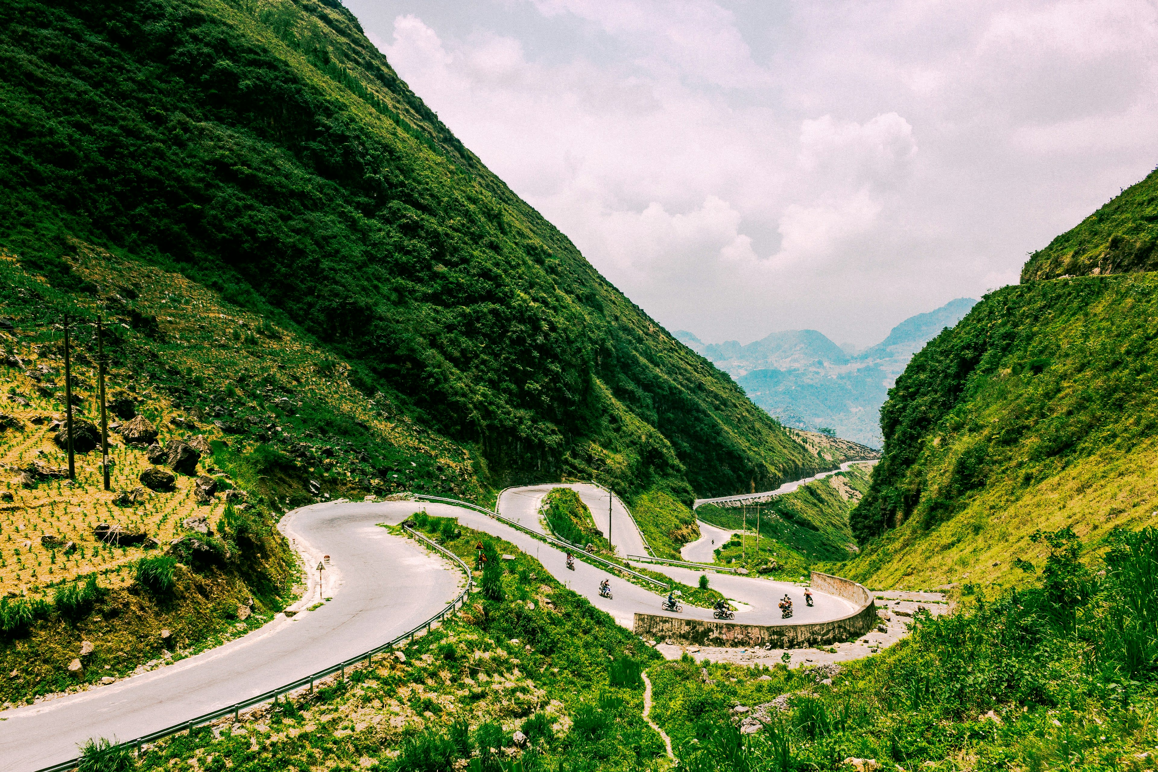 Switchback road climbing a green limestone valley in northern Vietnam