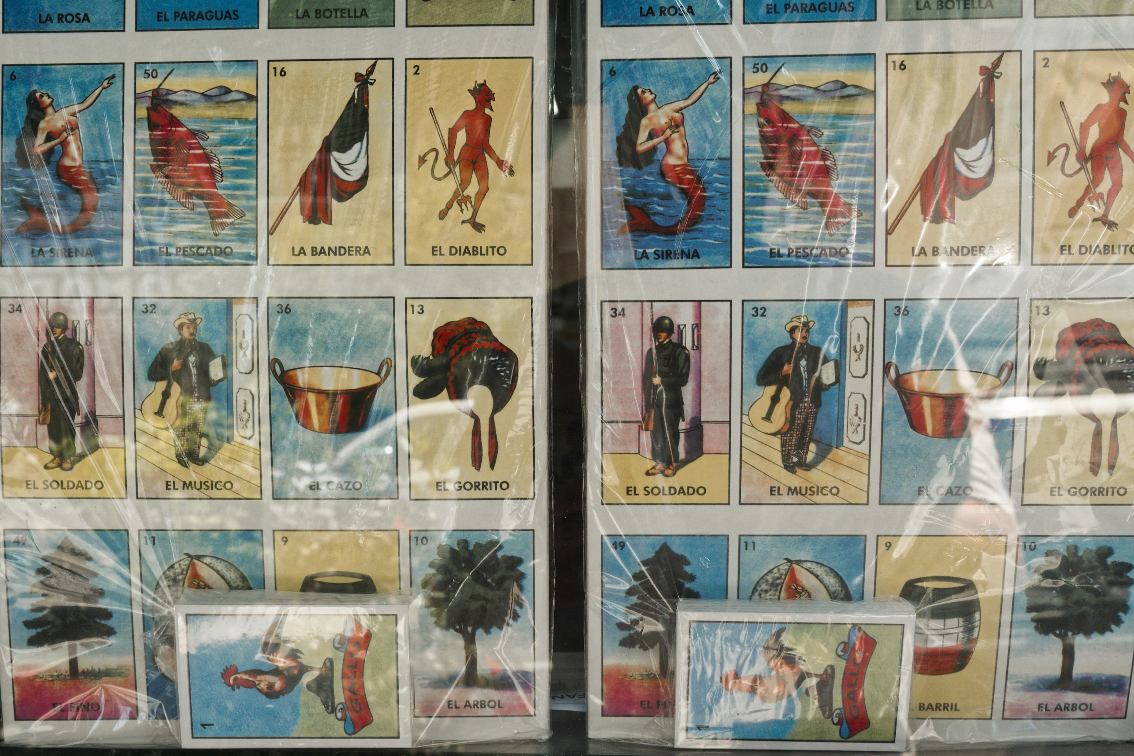 A shop window covered in colourful lotería game cards