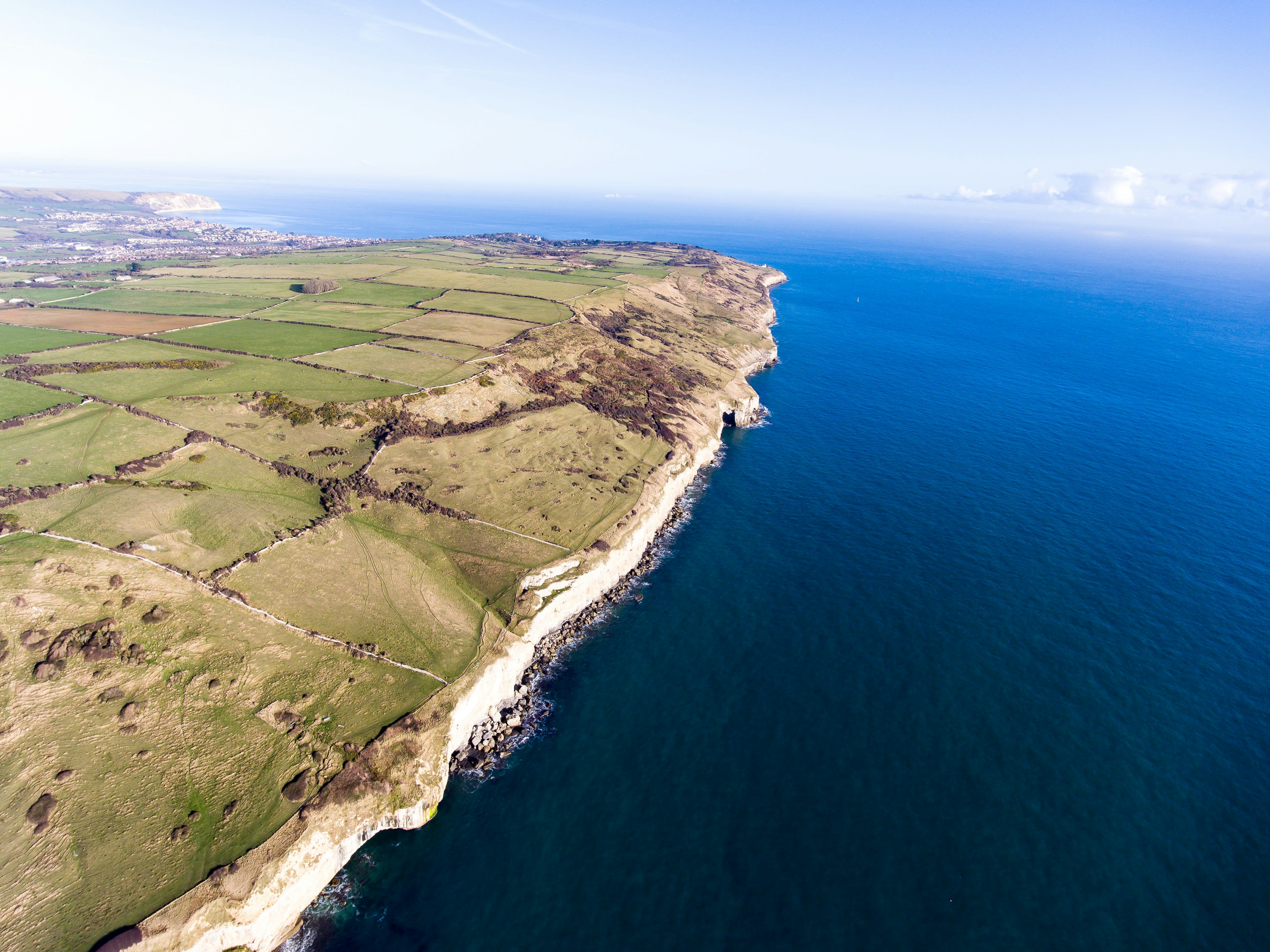 Aerial view of high dark cliffs meeting deep blue Atlantic water