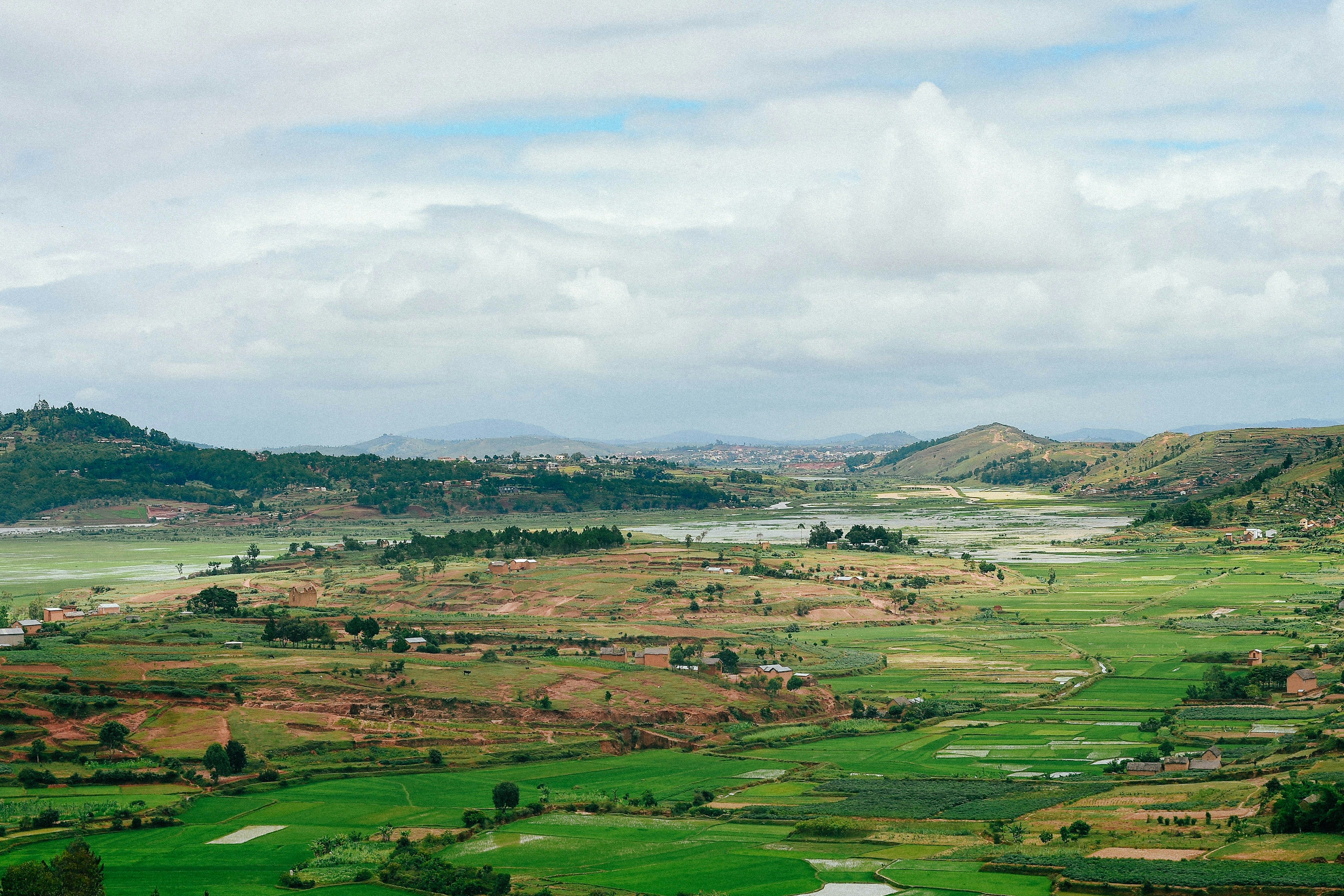 Terraced green rice valleys and hills under a cloudy sky