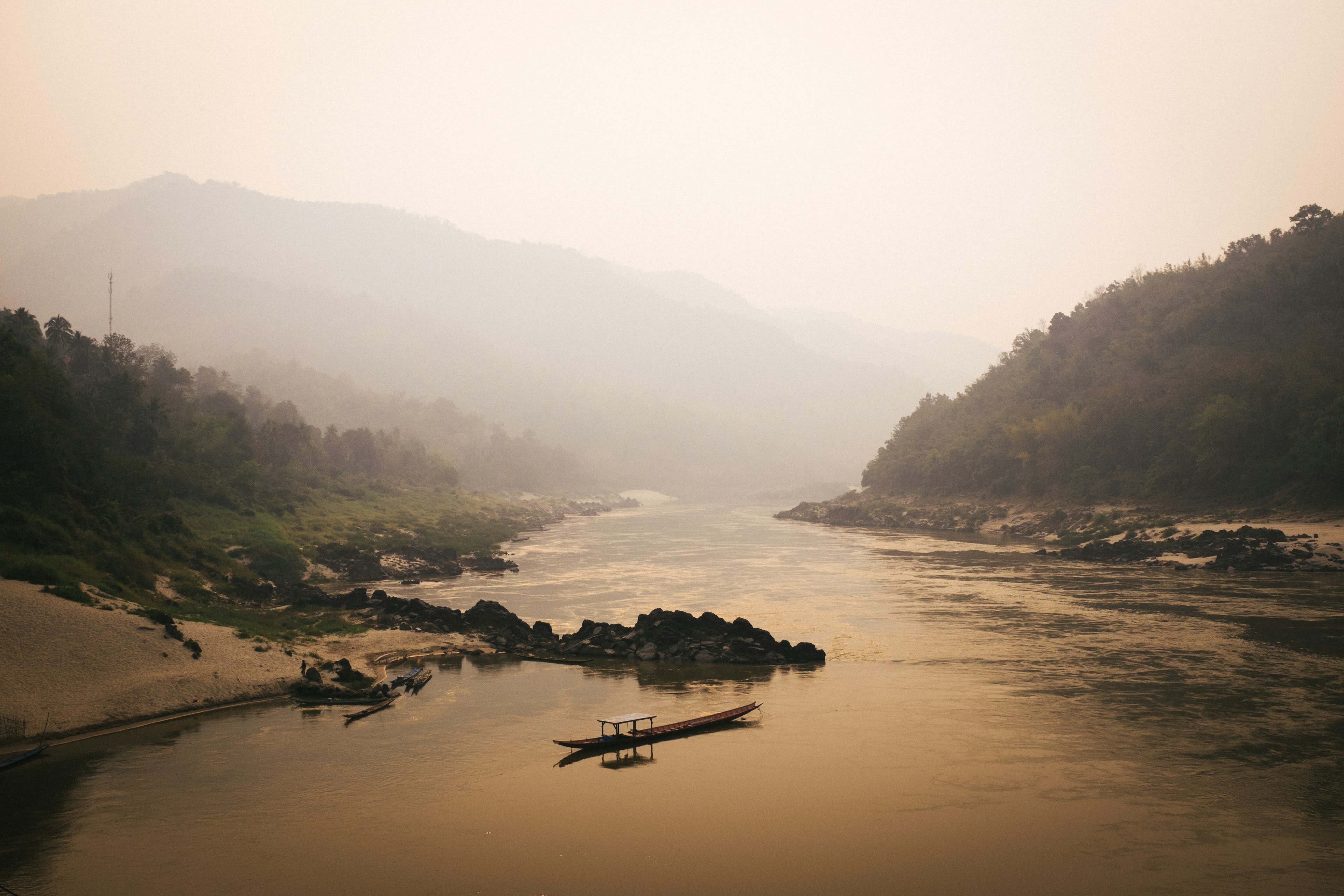 The Mekong winding between dark hills under a smoky rose sunset