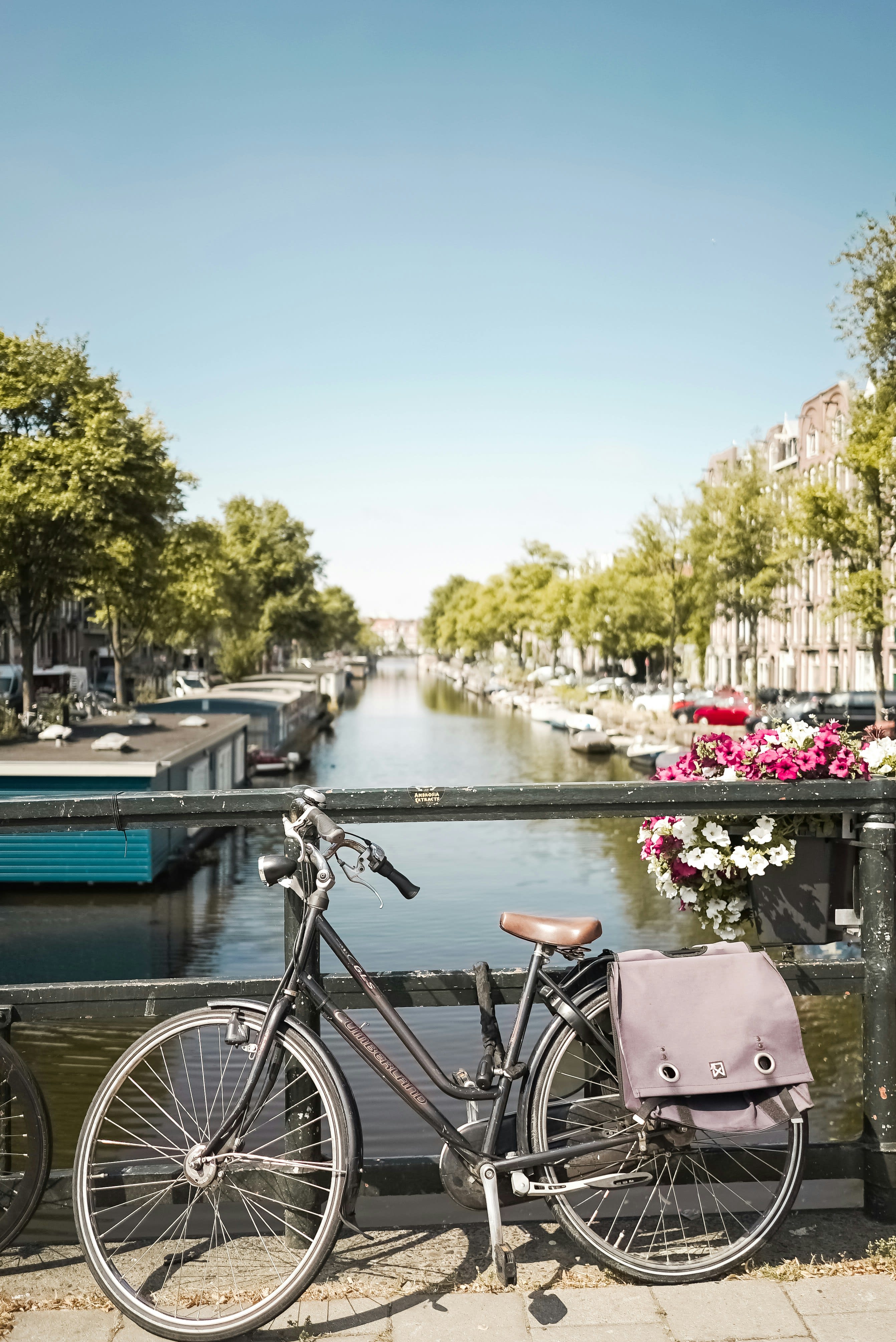 A Dutch city bike leaning against a canal bridge railing