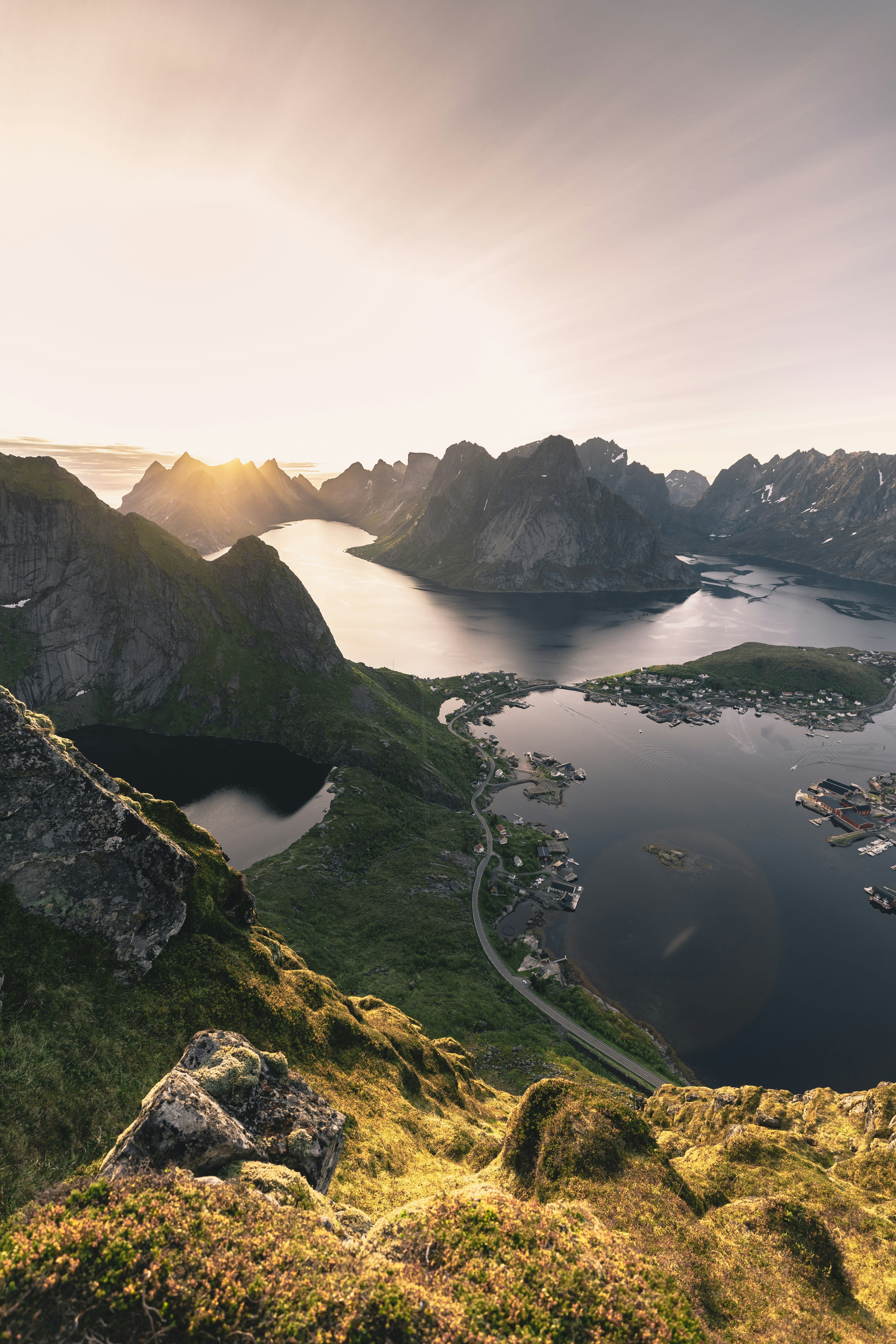 A high view down onto islands, causeways and a village between mountains and sea