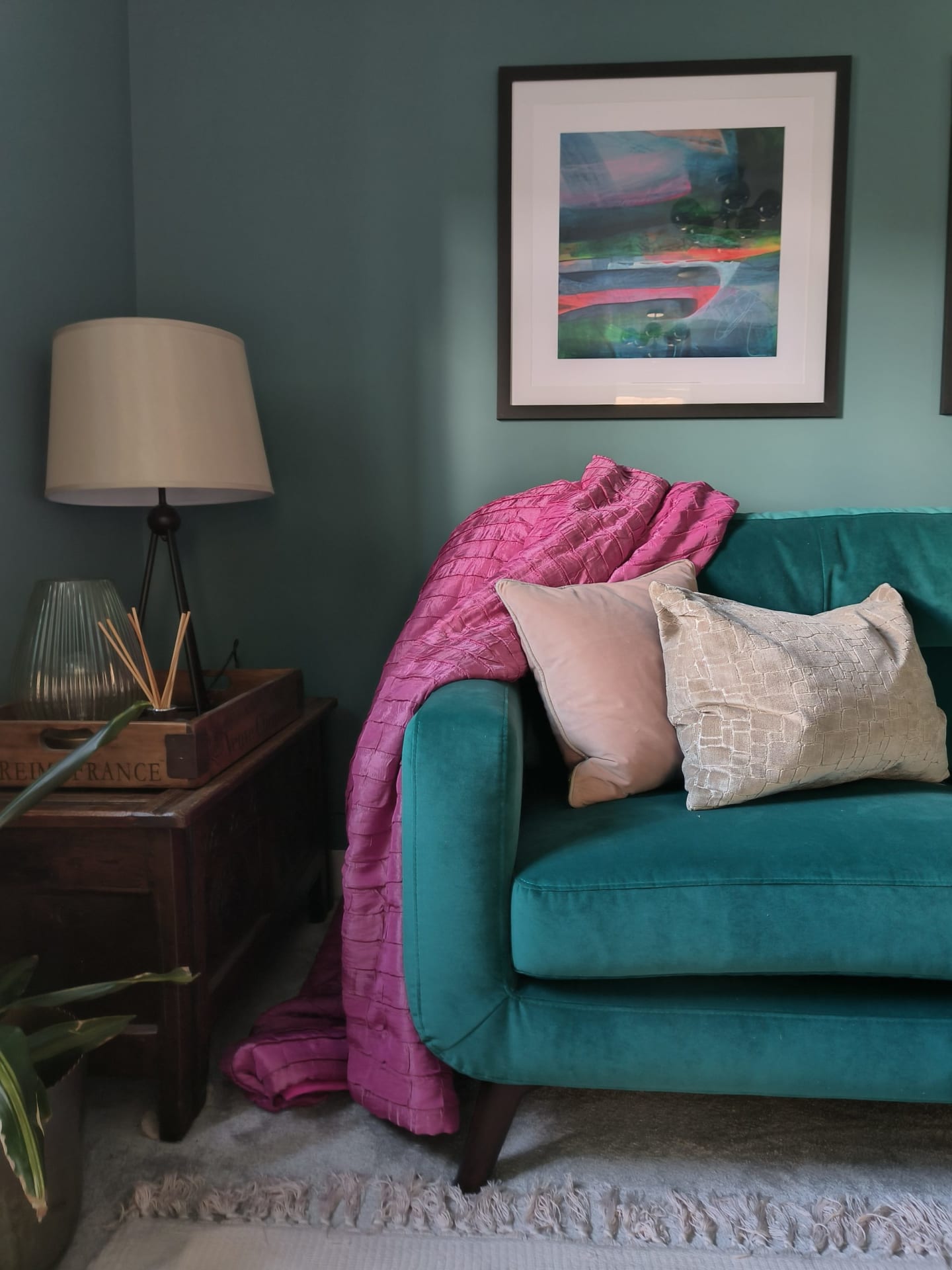Pink throw over teal sofa