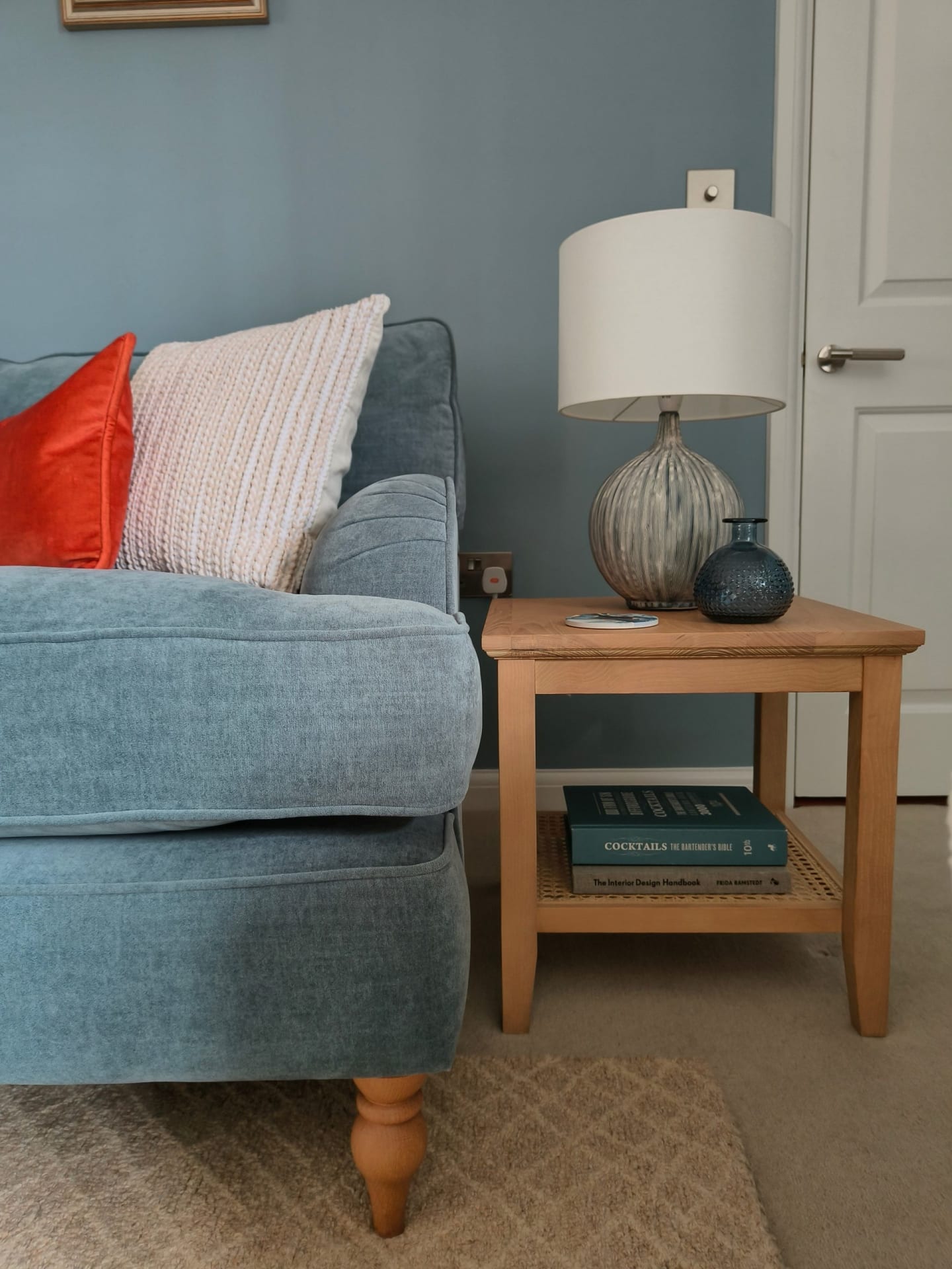 Blue sofa in blue living room with orange accents