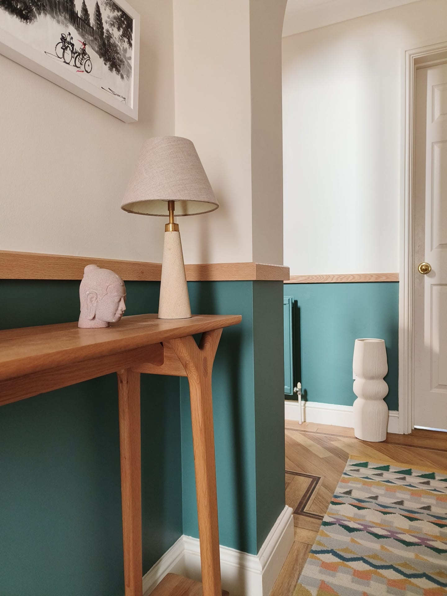 Teal and oak hallway entrance with geo rug