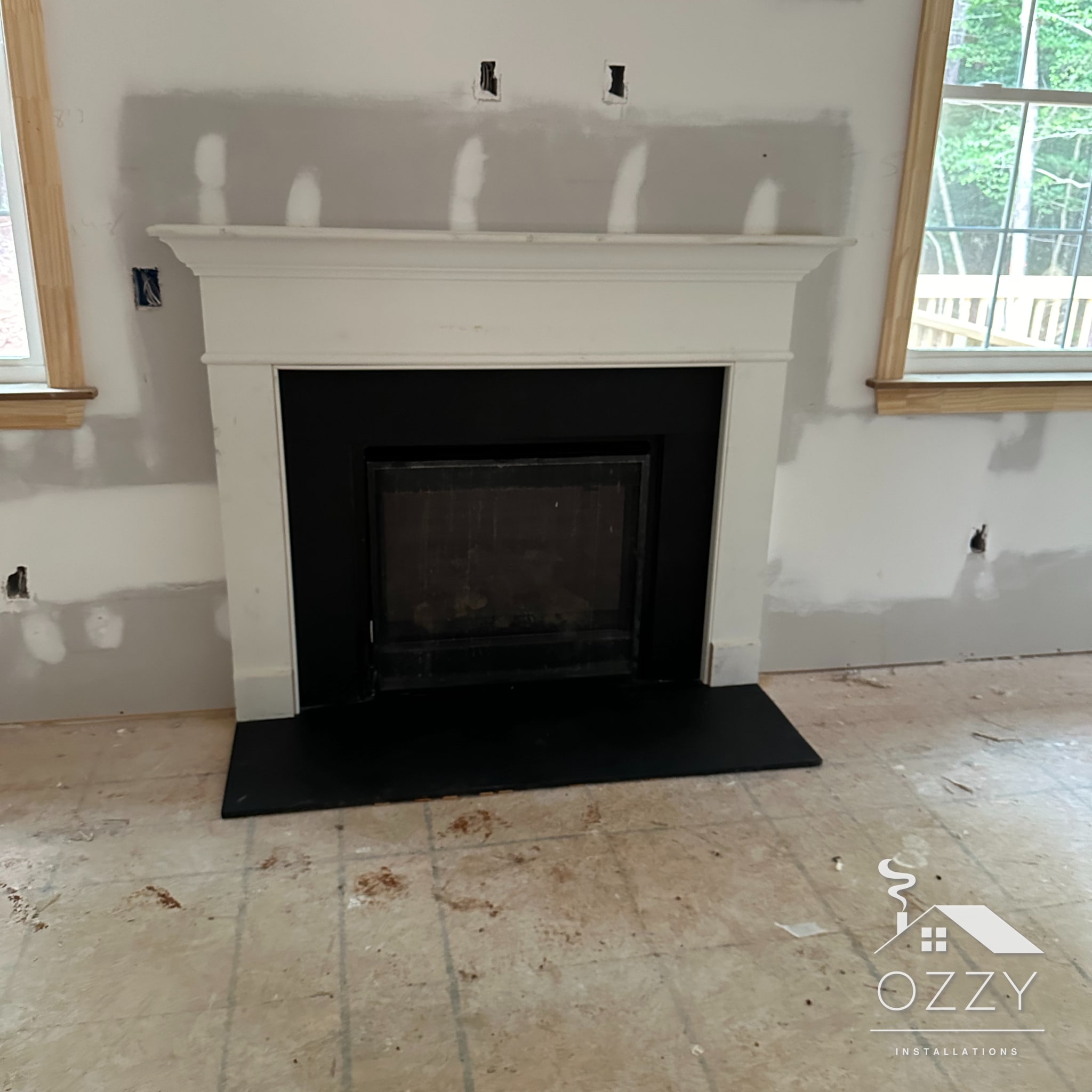 White mantel and black hearth installed in a new-construction home