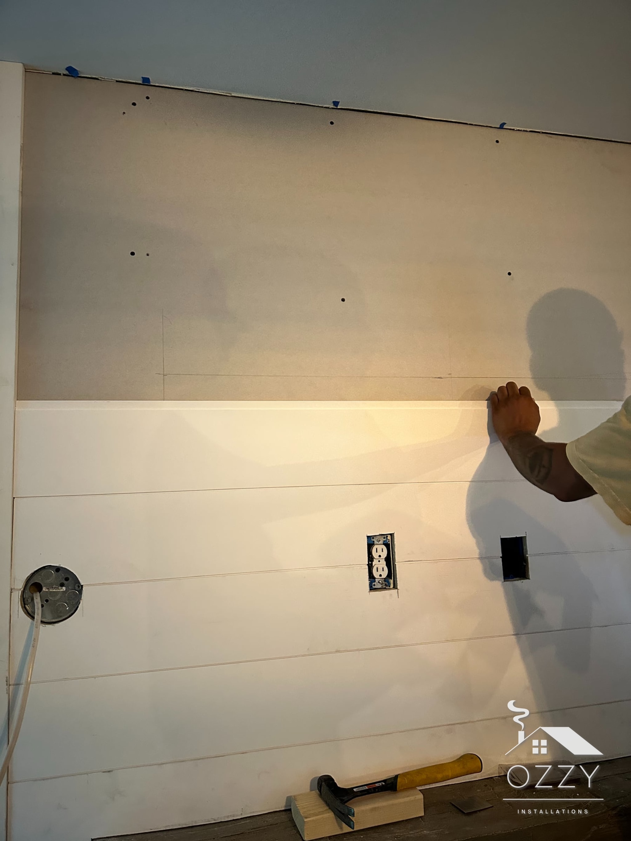 Shiplap boards going up on the wall above the fireplace
