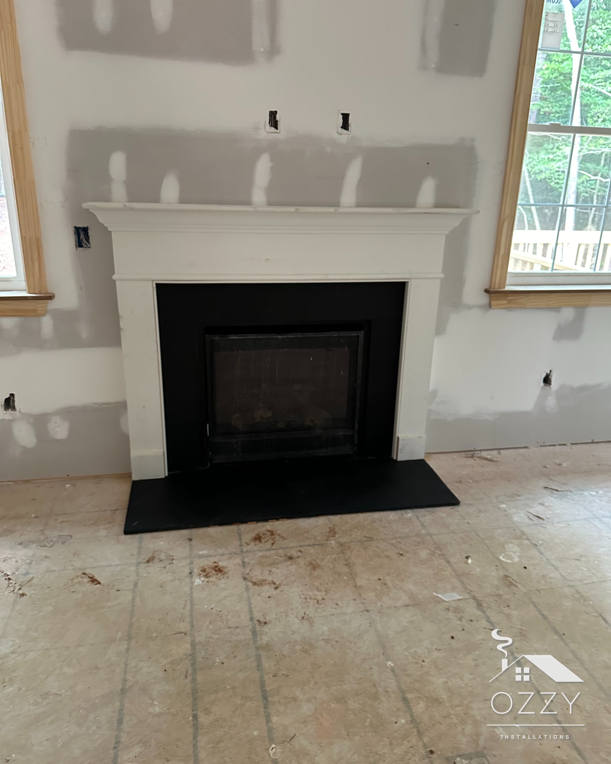 White mantel and black hearth installed in a new-construction home