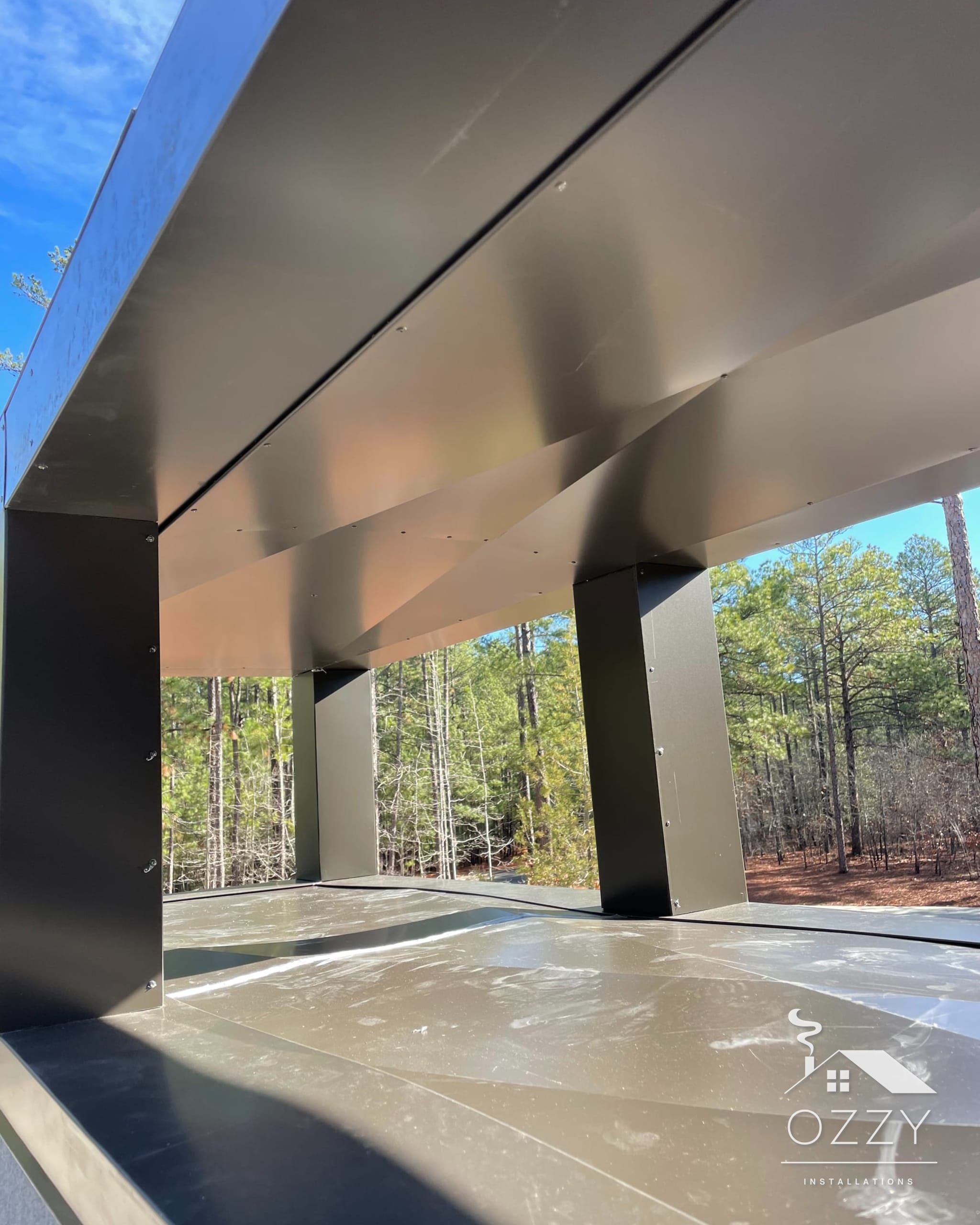 Boxy black chimney shroud with open sides on a light chimney