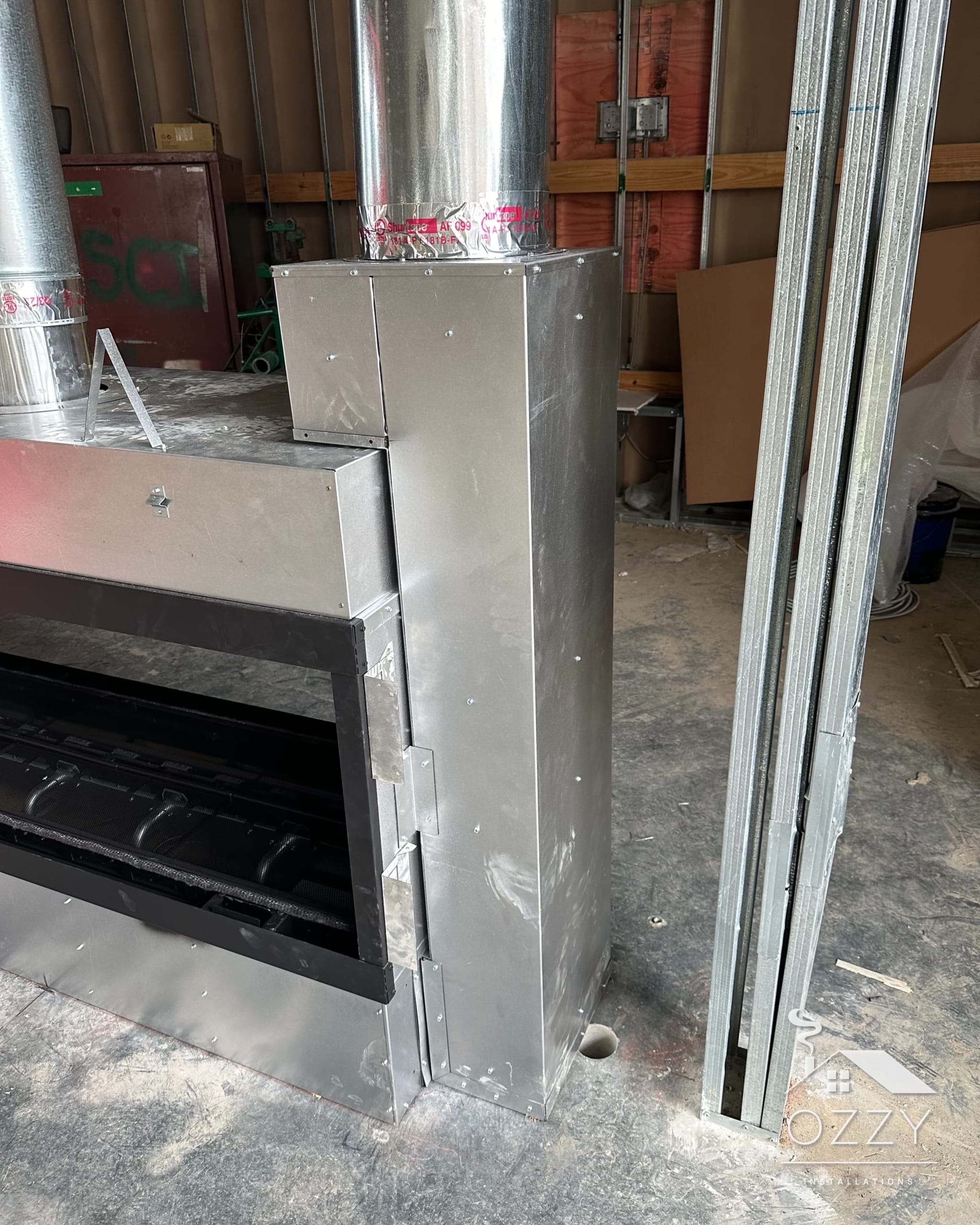 Steel linear fireplace units framed in on an unfinished commercial floor