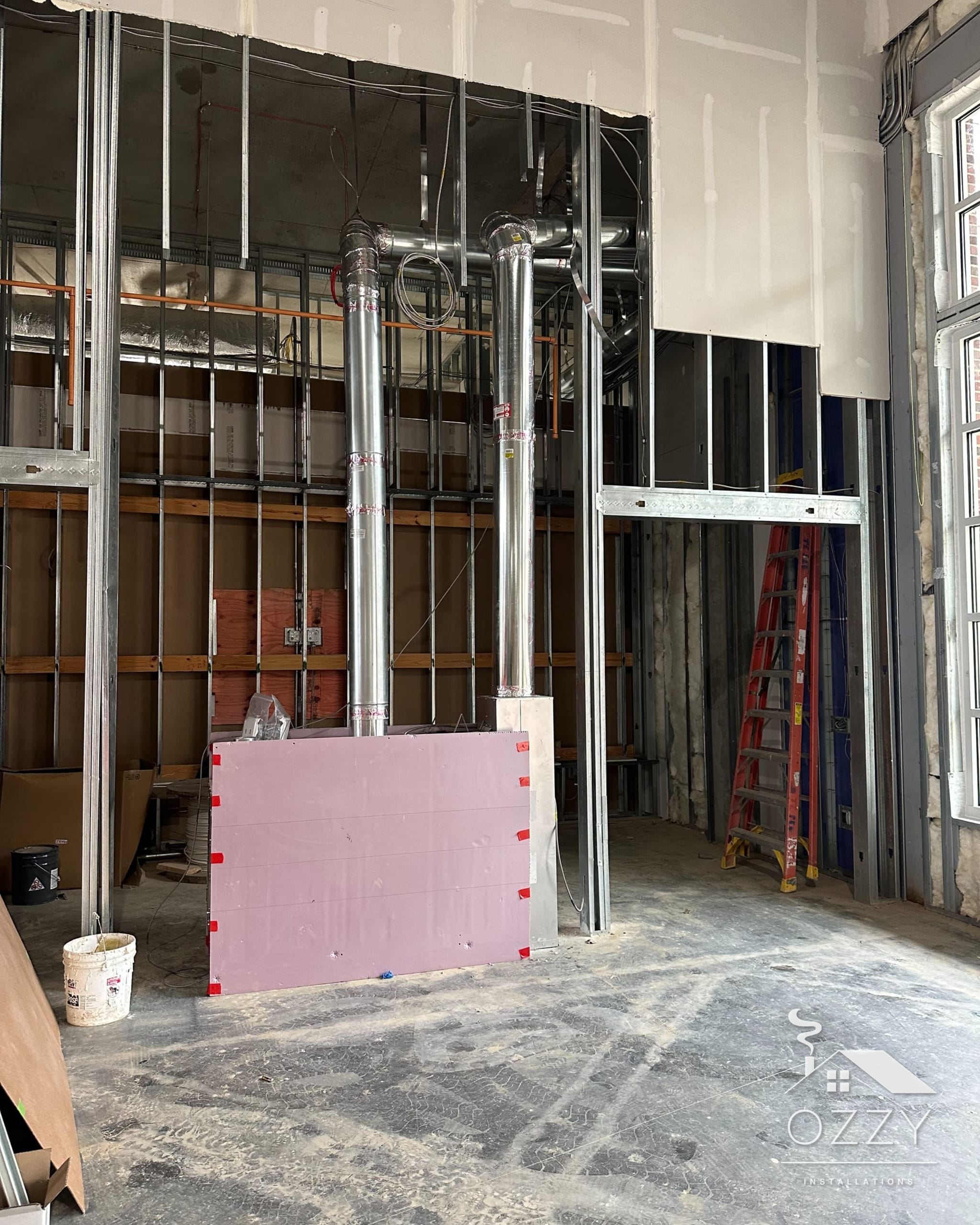 Stainless steel vent pipes rising through an unfinished multi-story building