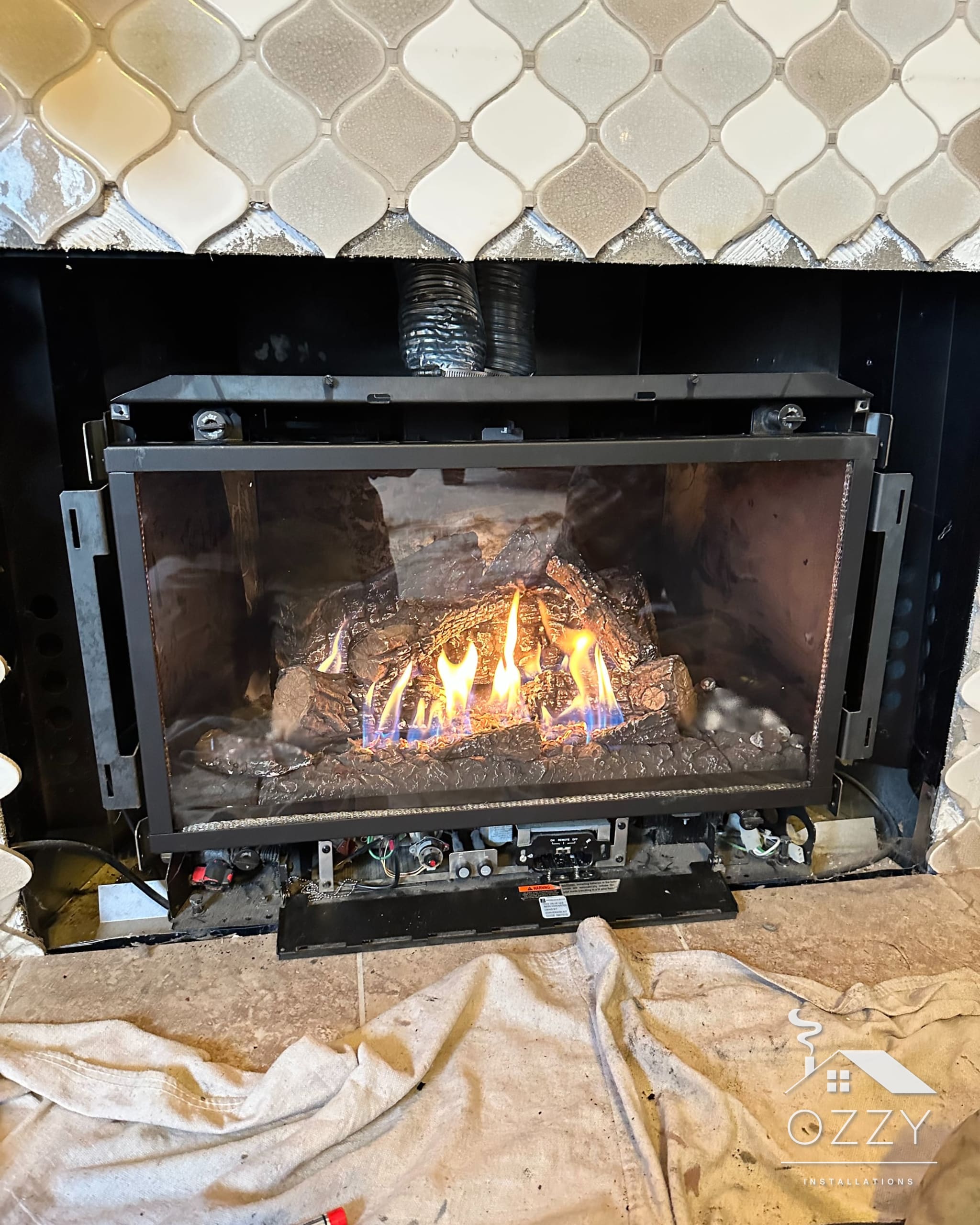 Gas fireplace insert lit and running behind a tile surround
