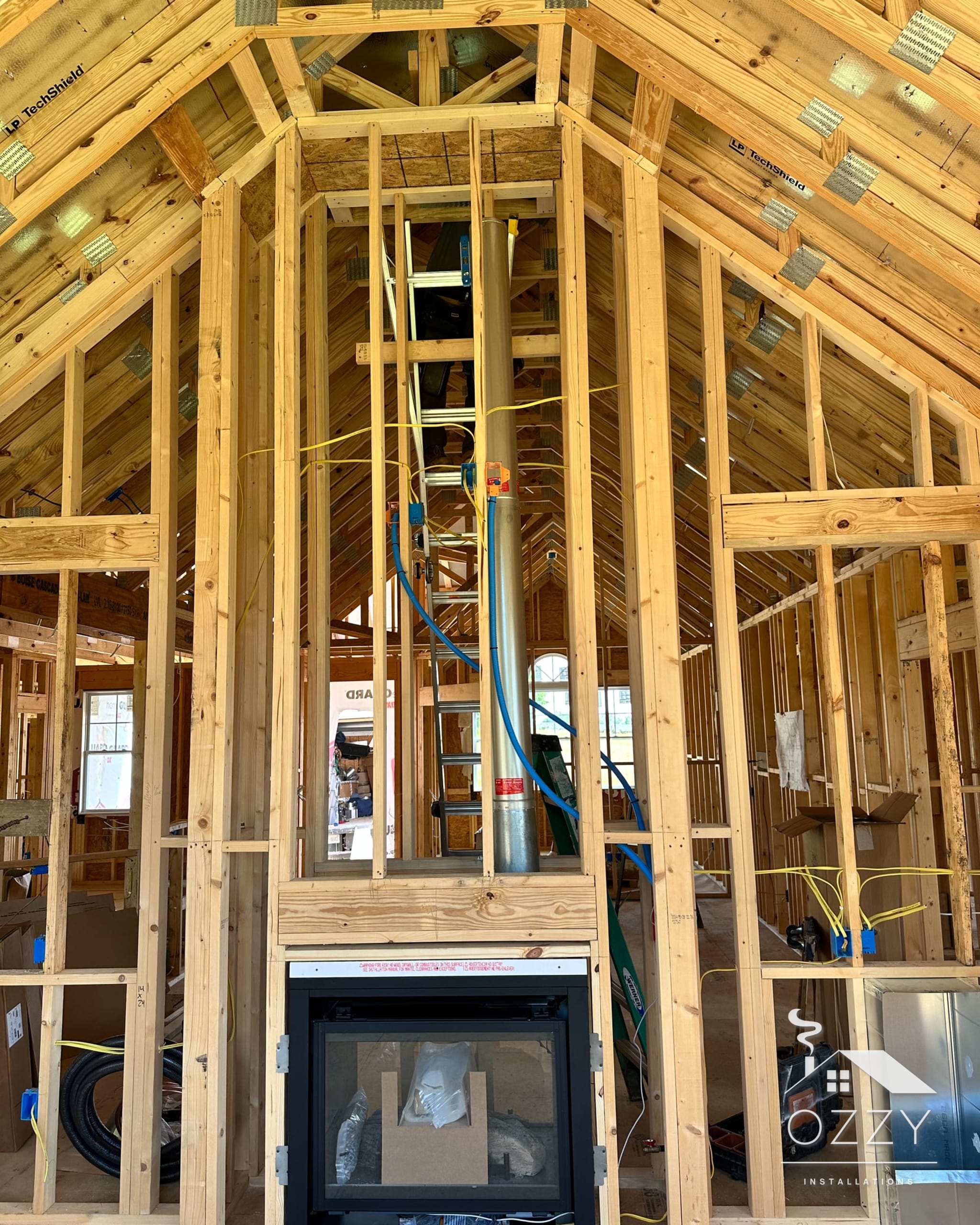 Fireplace set at the base of a tall framed chase inside a new home