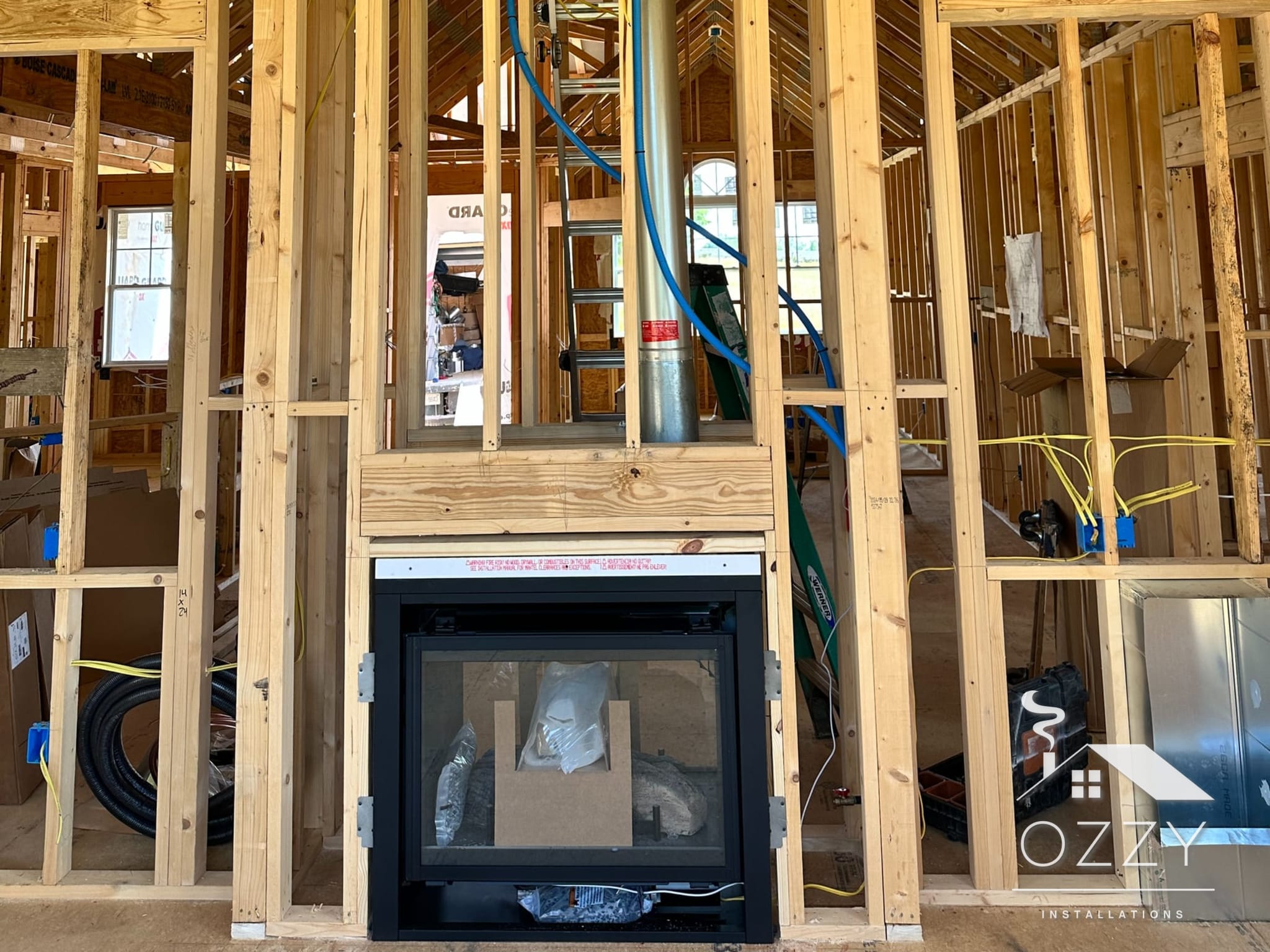 Fireplace set at the base of a tall framed chase inside a new home