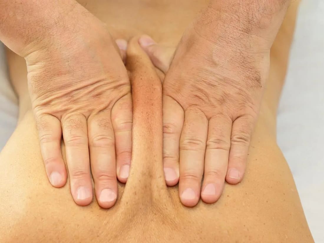 Hände beim Üben eines Massagegriffs am Rücken