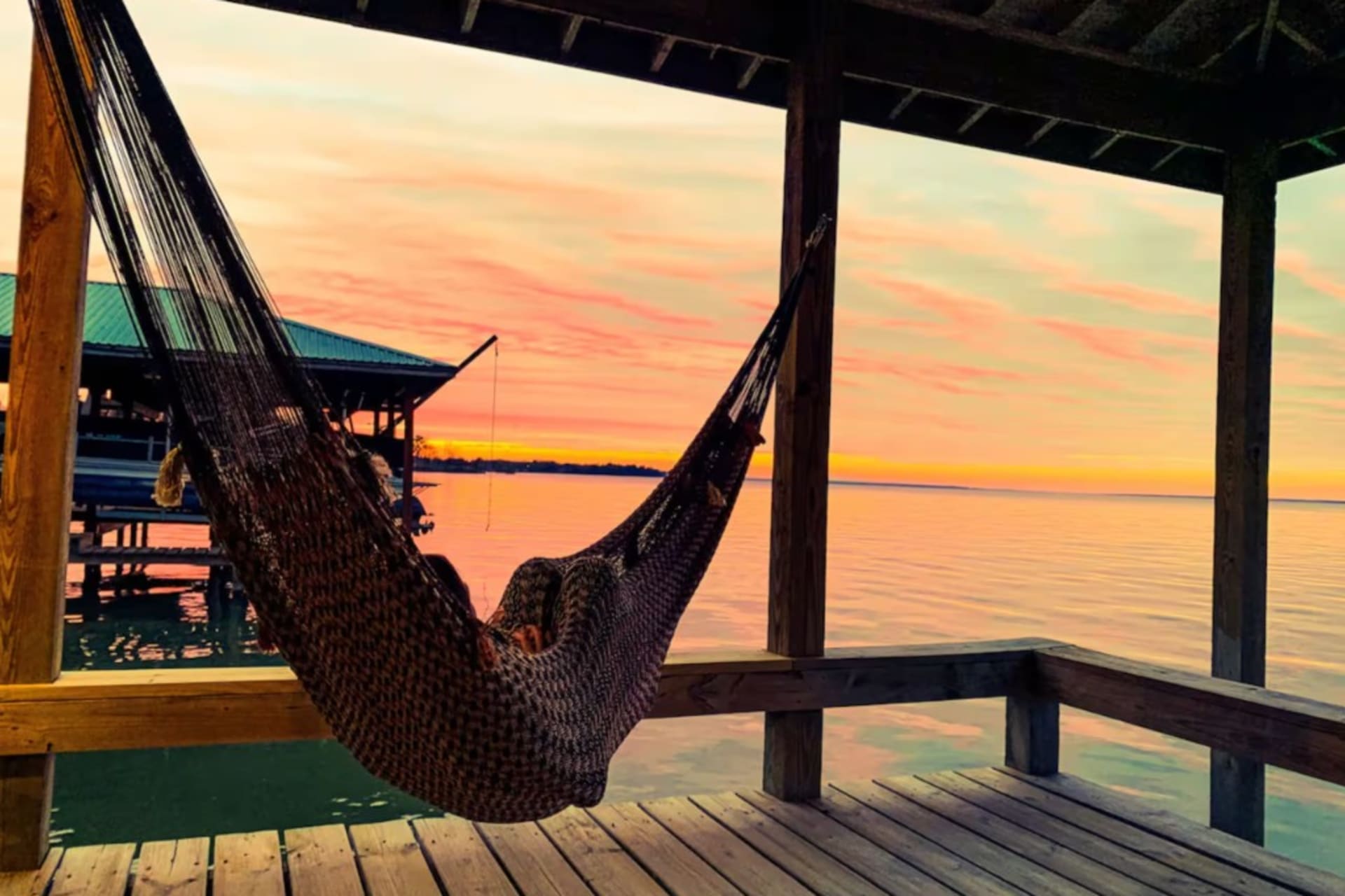 Hammock on the covered dock overlooking Lake Livingston at sunset — a quiet invitation to rest