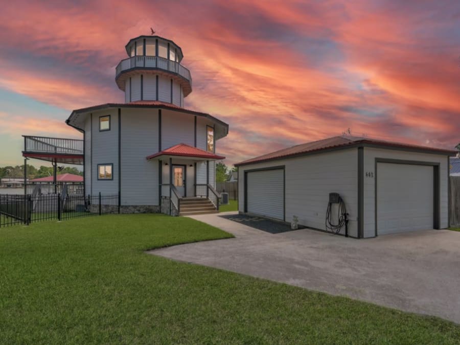 Lighthouse home and matching garage at sunset beside the water