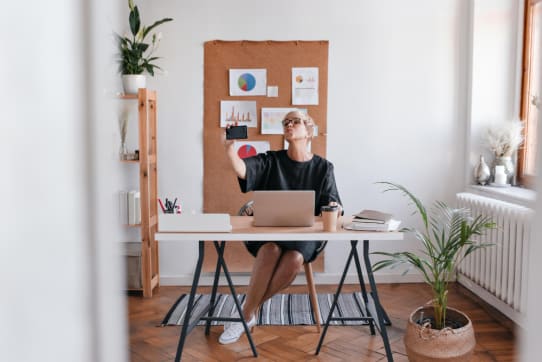 | Sohnne® Person using workspace furniture in a bright, organized home office that promotes focus and clarity.