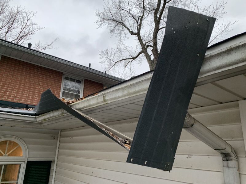 gutter guards wind damage blown off and dangling from the gutters