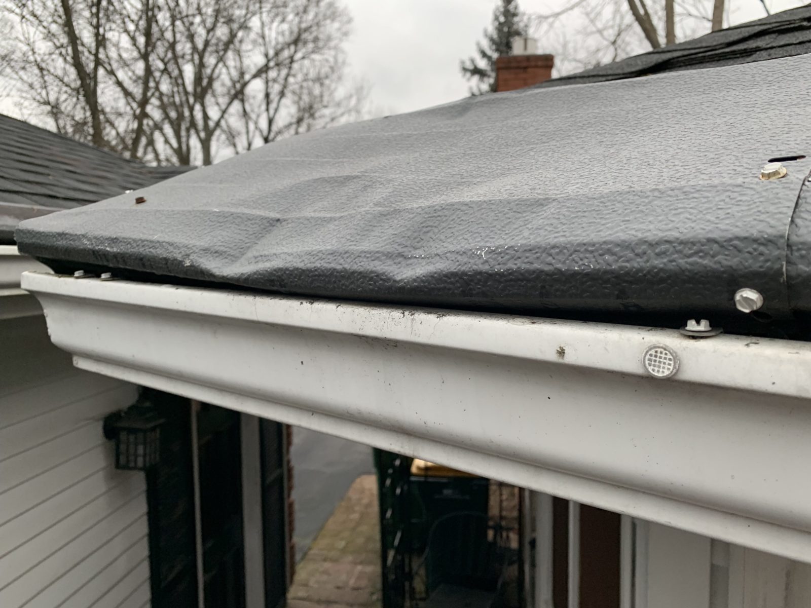 gutter guards dented by fallen limbs due to high winds and storm damage