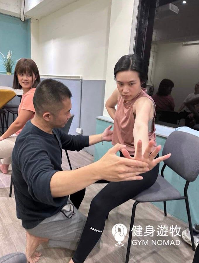 承豪老師也會細緻的調整每個人的動作，感受到出力部位｜圖源：健身遊牧