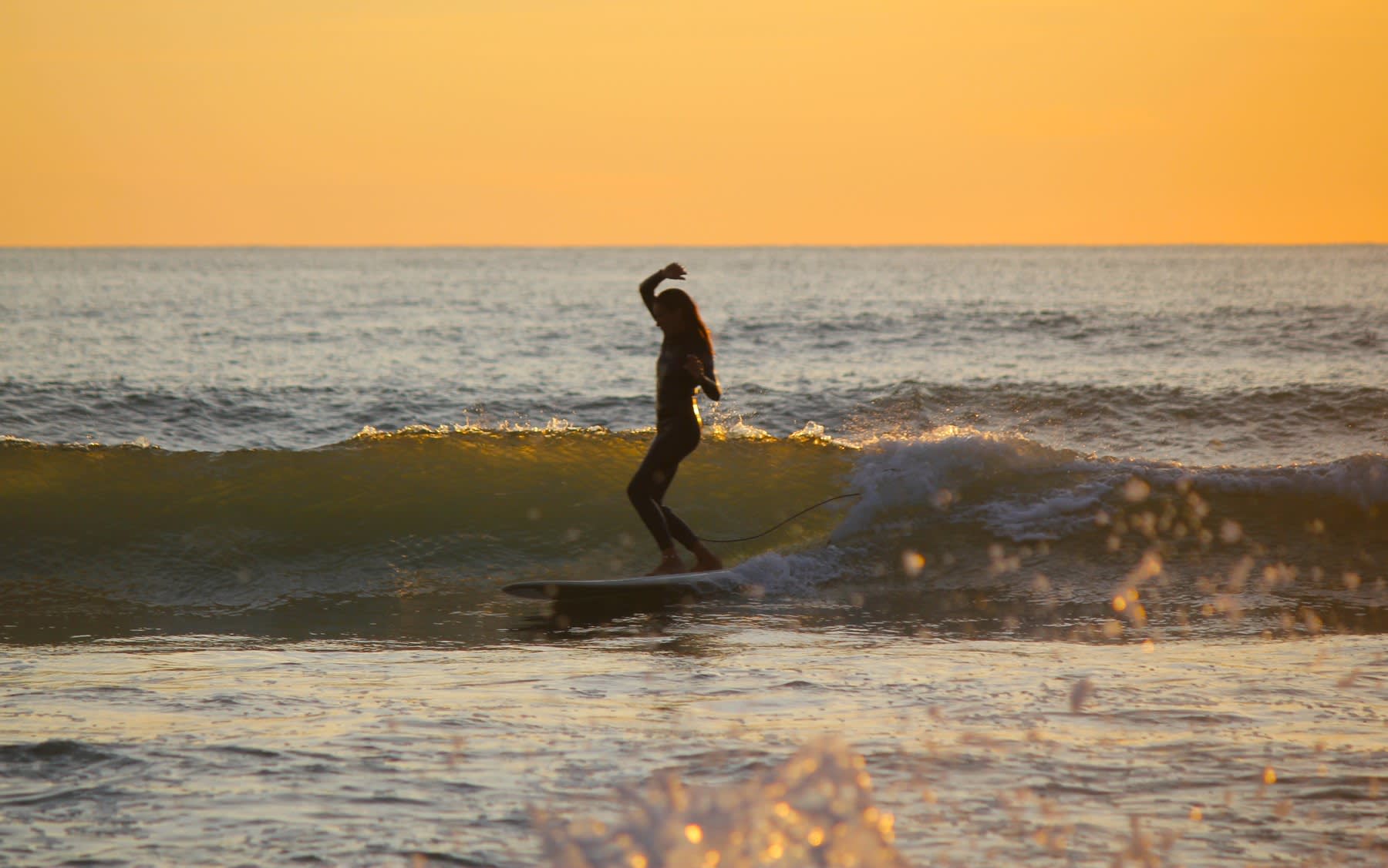 Surf con luz dorada sobre el mar