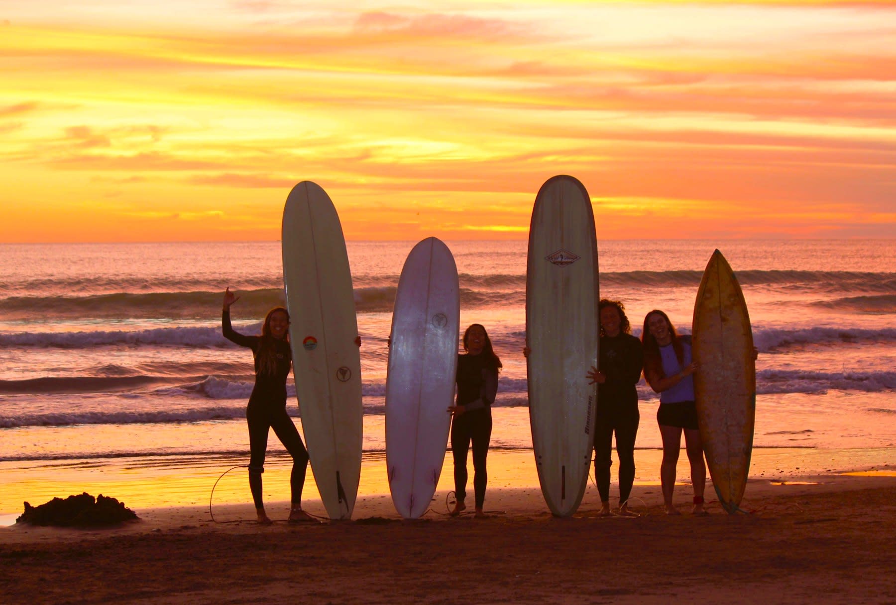 Tablas y personas frente al mar con luz cálida