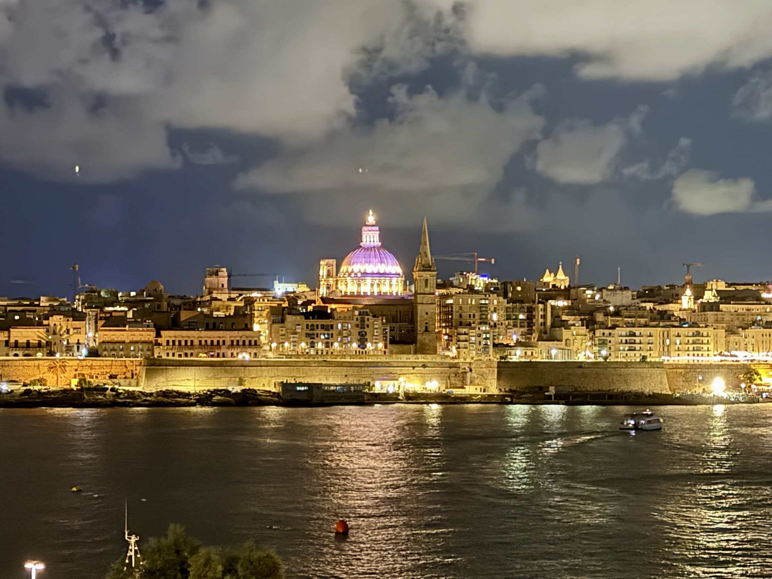 Valletta skyline lit up at night across the harbour, Malta
