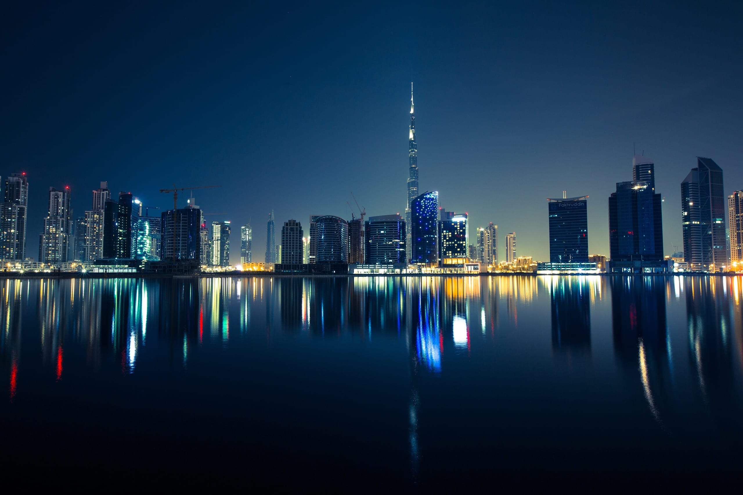 Dubai skyline and Burj Khalifa reflected in the water at night