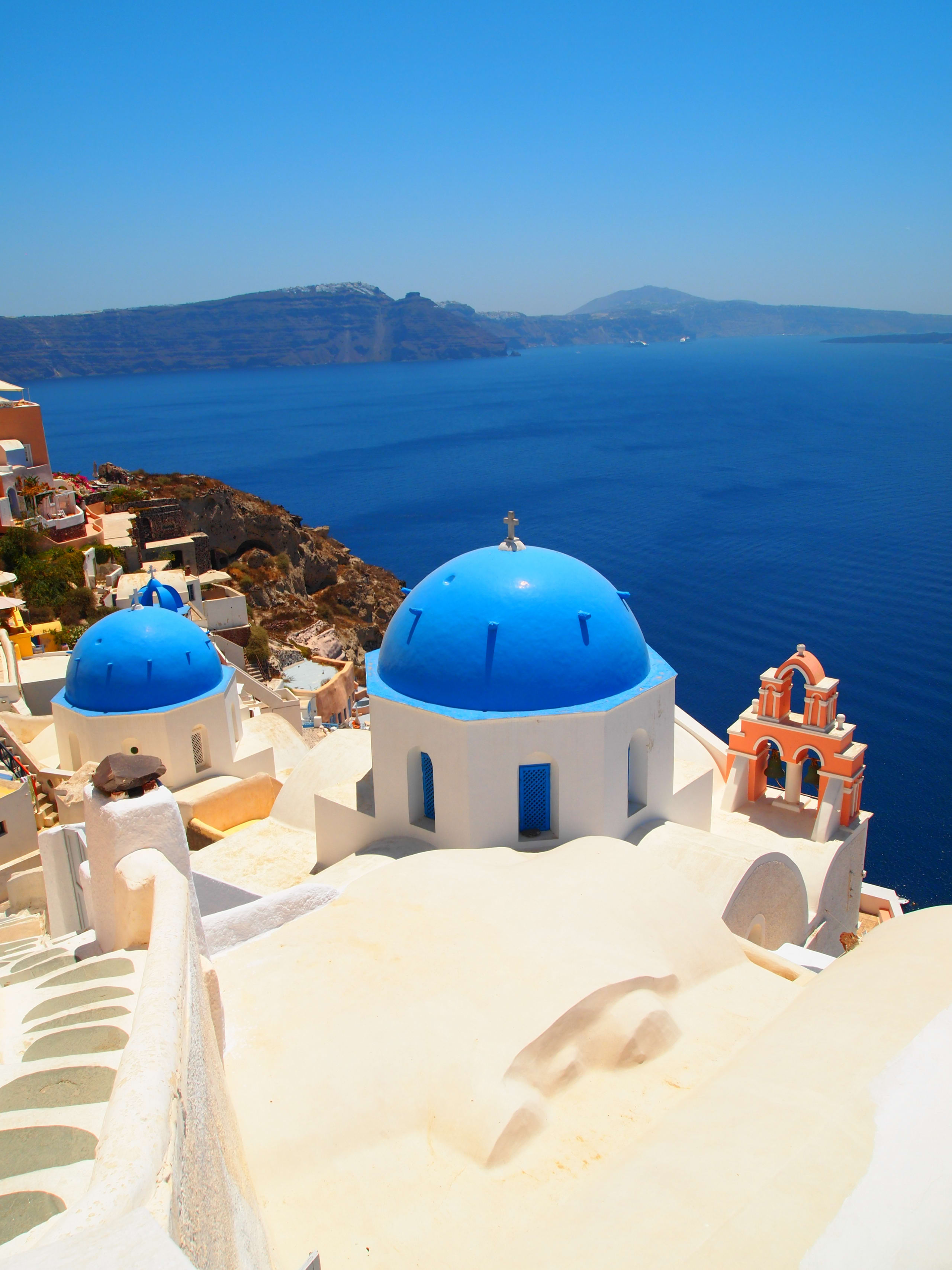 Blue-domed churches above the Aegean Sea in Oia, Santorini, Greece