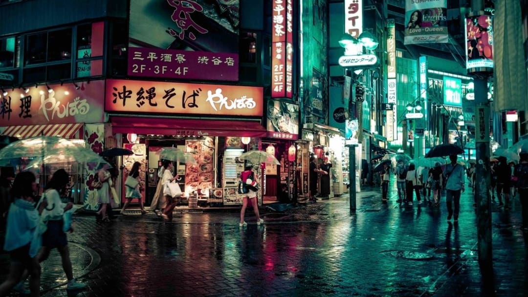 A Tokyo street lit with neon signs at night