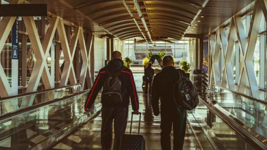 Travellers with suitcases walking through an airport