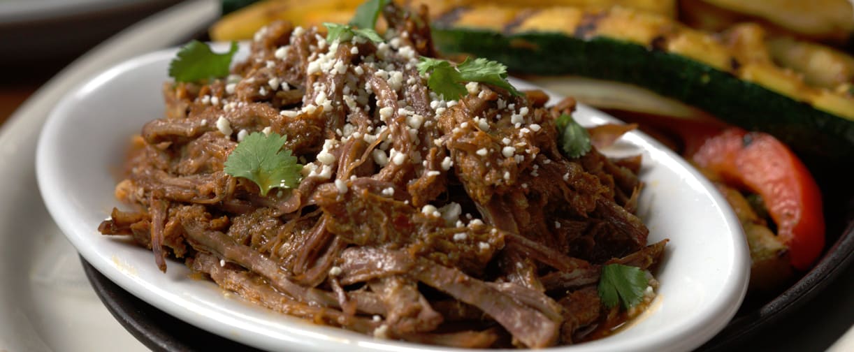 barbacoa beef fajitas served with grilled vegetables, rice and beans