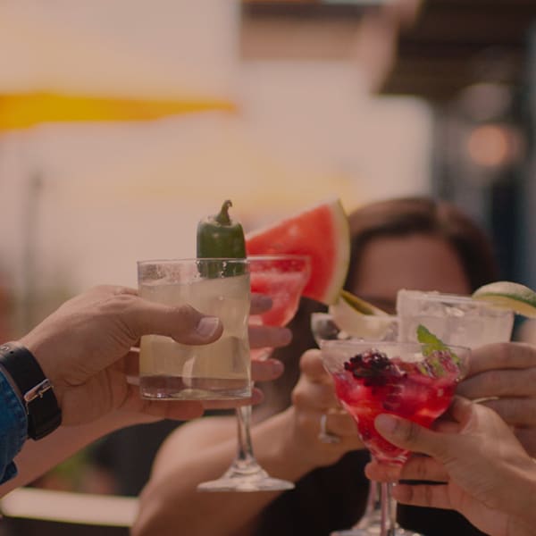 group of people cheers multiple drinks together outside