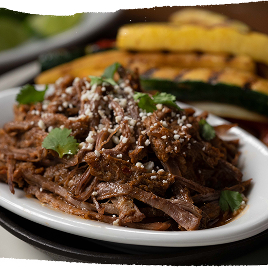 barbacoa beef fajitas served with grilled vegetables, rice and beans