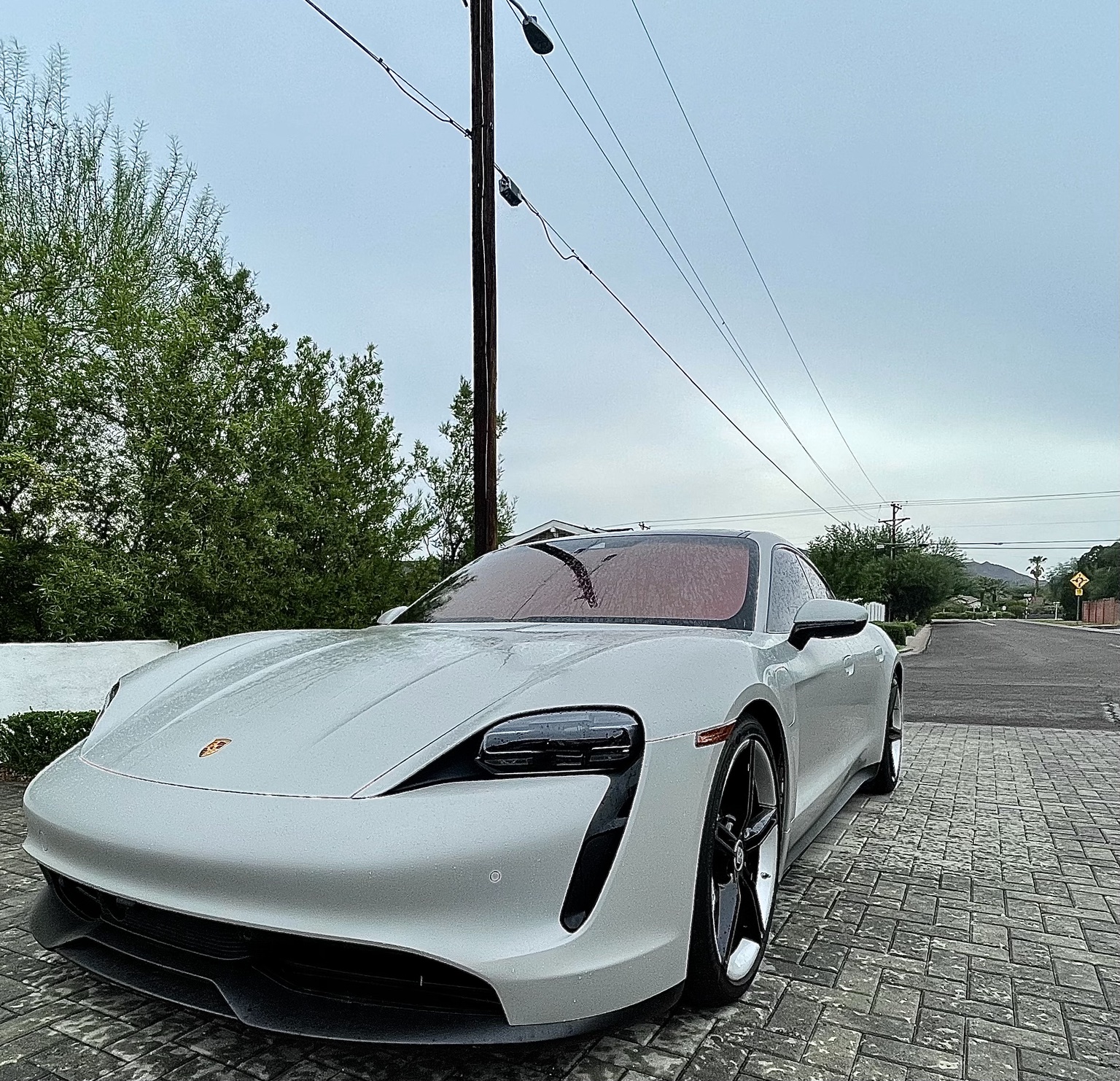 White Porsche Taycan photographed at a residence after professional window tint service