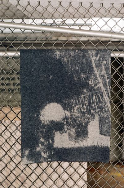 half-wet low res rugs grey felted Spectral Orb rug hanging from a fence. photo by Christian Michael Filardo