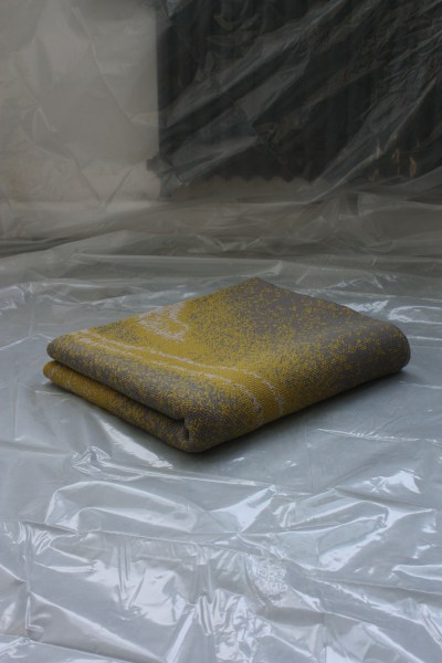 green and grey, folded knit blanket on a tarp