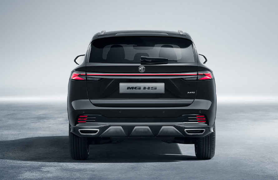 The rear view of a black MG HS SUV, showcasing its wide LED taillight bar with red accents